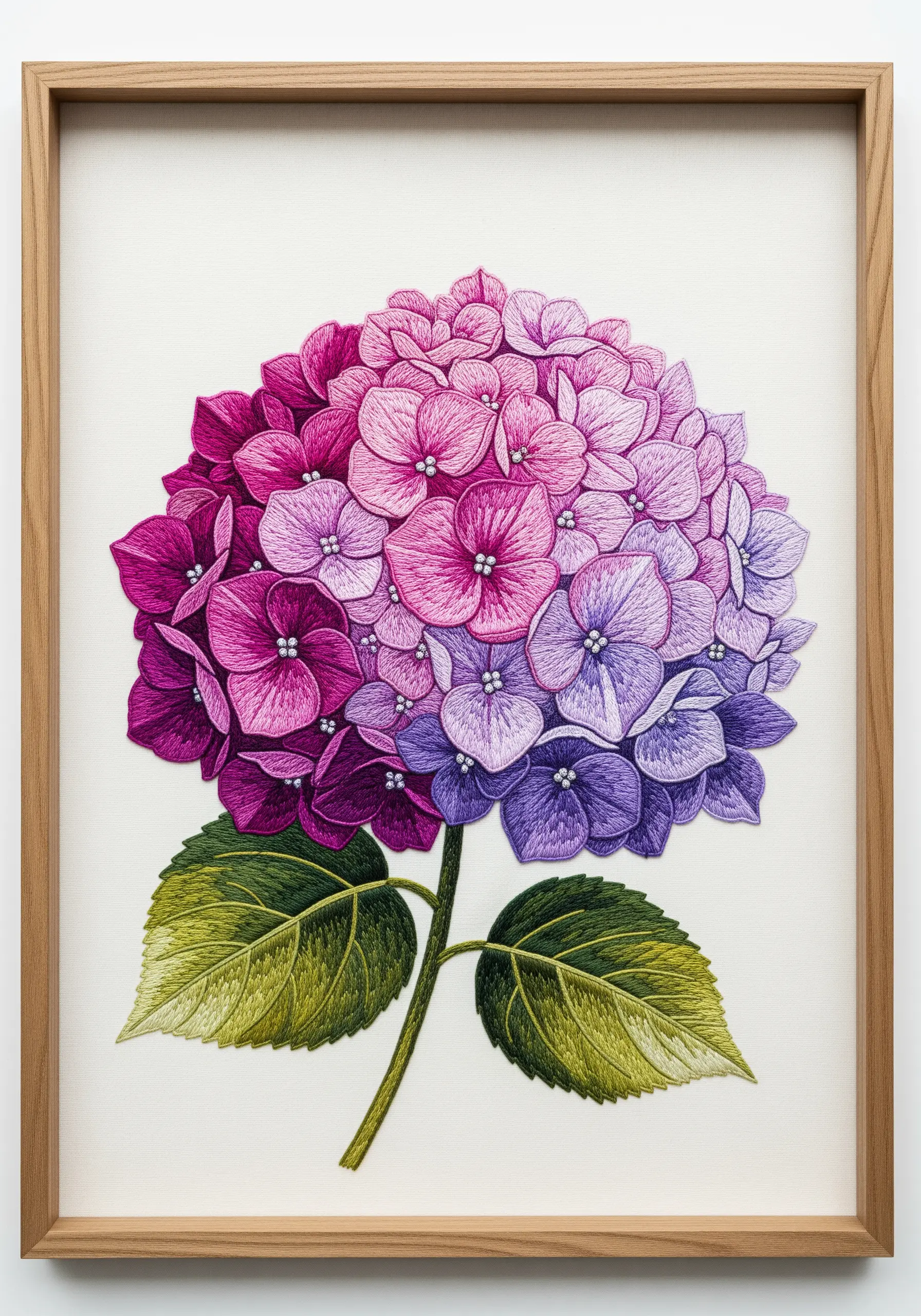 Framed embroidery of a single large hydrangea with a bold gradient from magenta to pink to purple.
