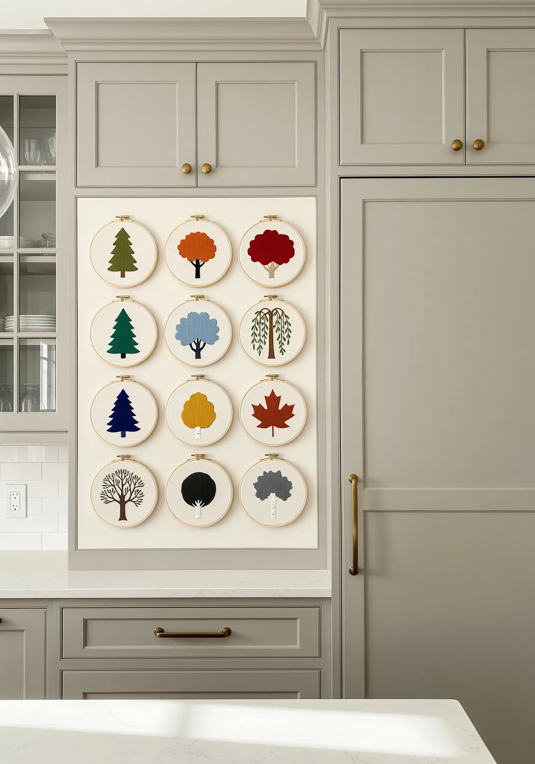 A grid of twelve embroidery hoops, each featuring a different stylized tree silhouette.