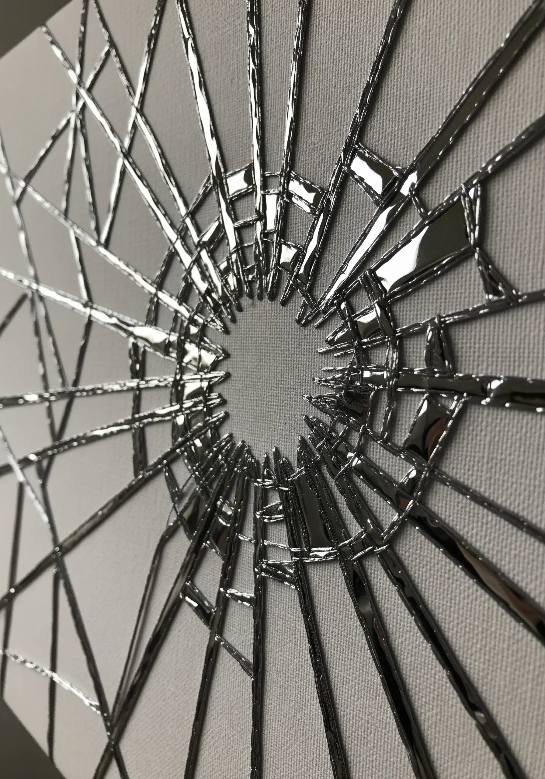 A shattered glass effect on canvas created with sharp fragments of silver metallic vinyl.