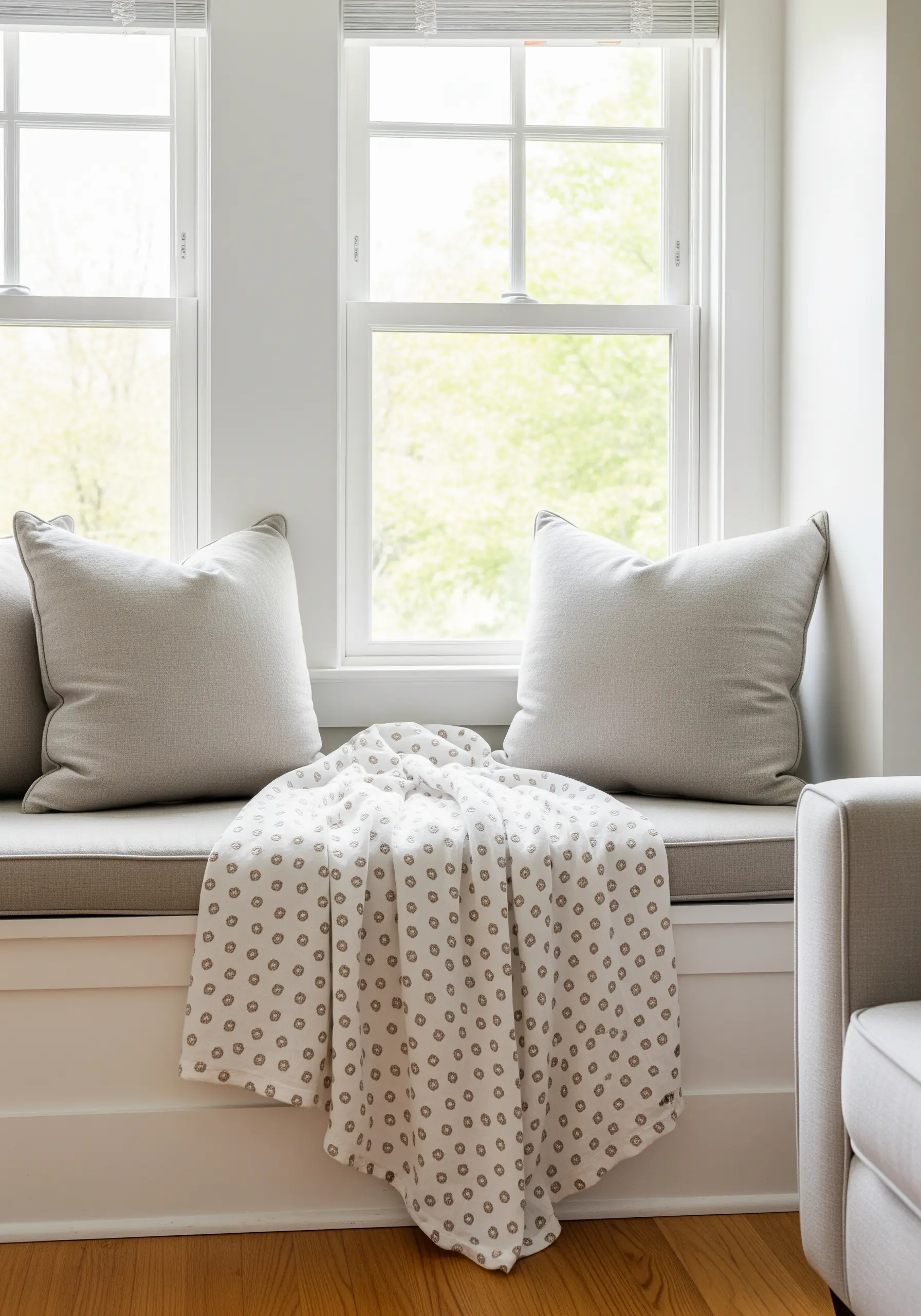 A repeating pattern of small, stylized floral motifs on a white throw blanket.