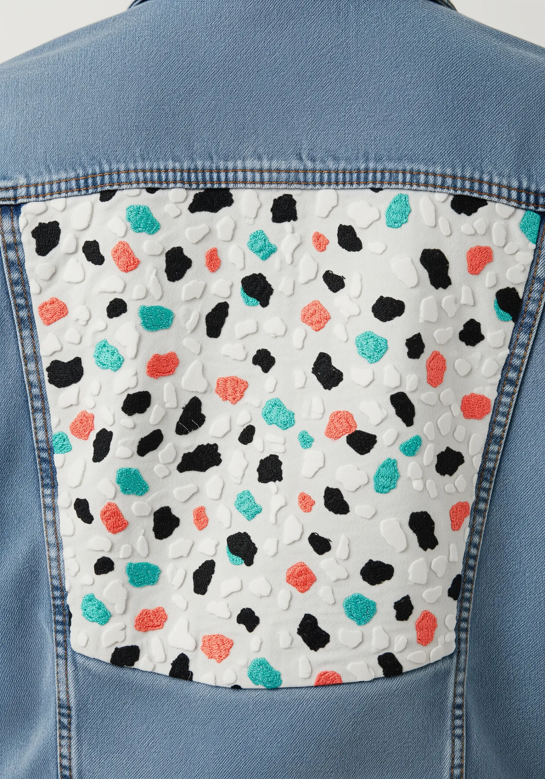 Embroidered terrazzo pattern with teal, coral, and black satin stitch 'chips'.