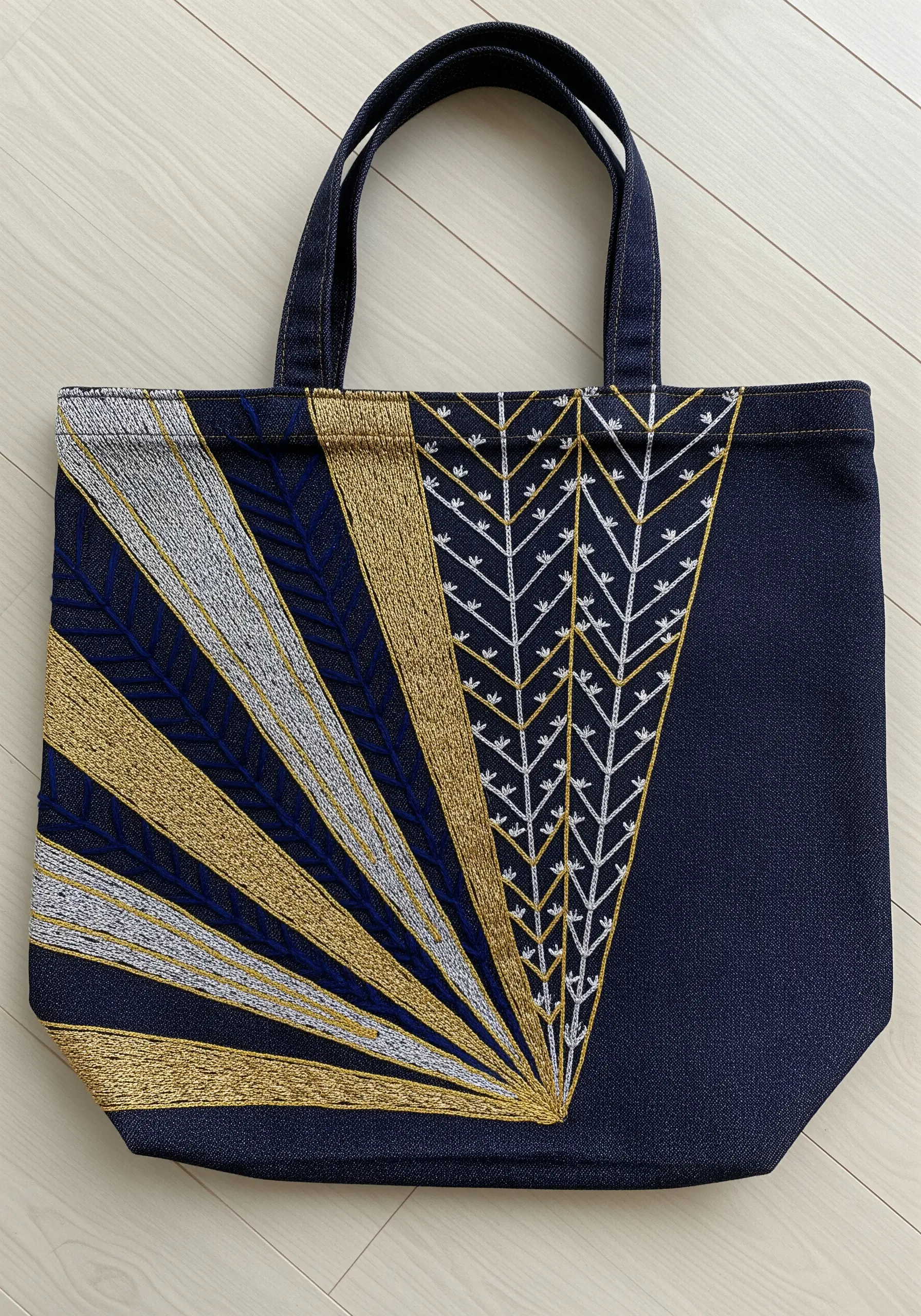 Art Deco sunburst design in gold, silver, and blue metallic threads on a denim tote