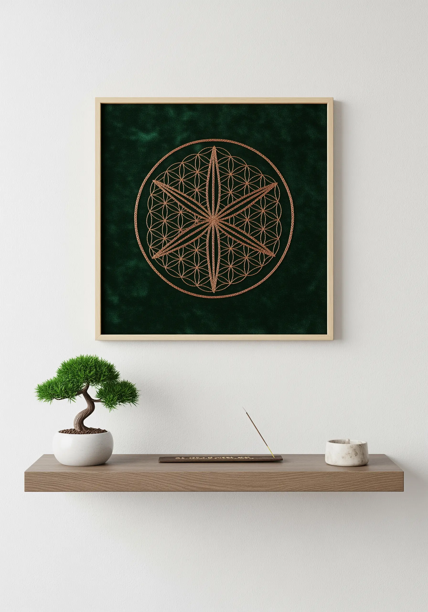 A framed piece of dark green velvet embroidered with a copper metallic Flower of Life.
