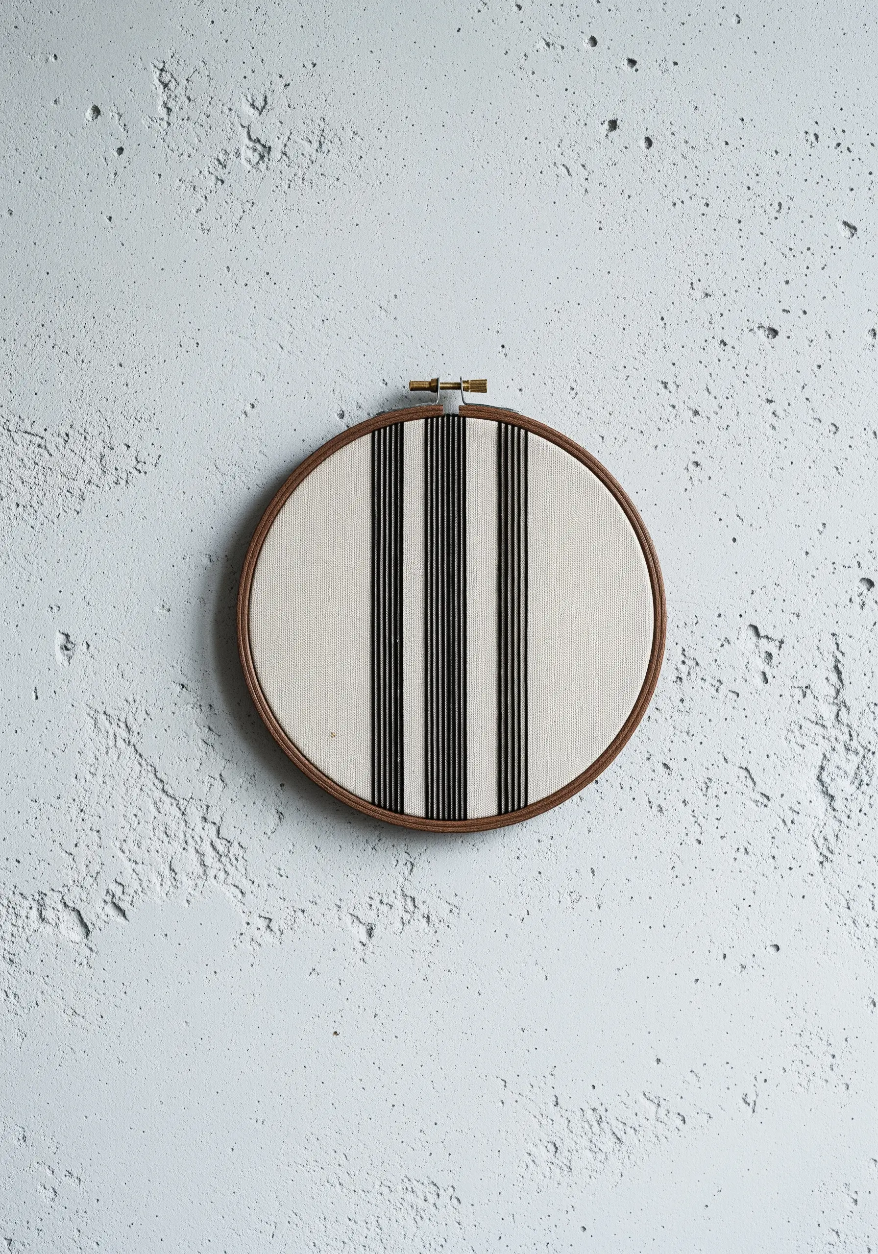 An oval hoop with bold vertical black stripes made from wrapped thread.