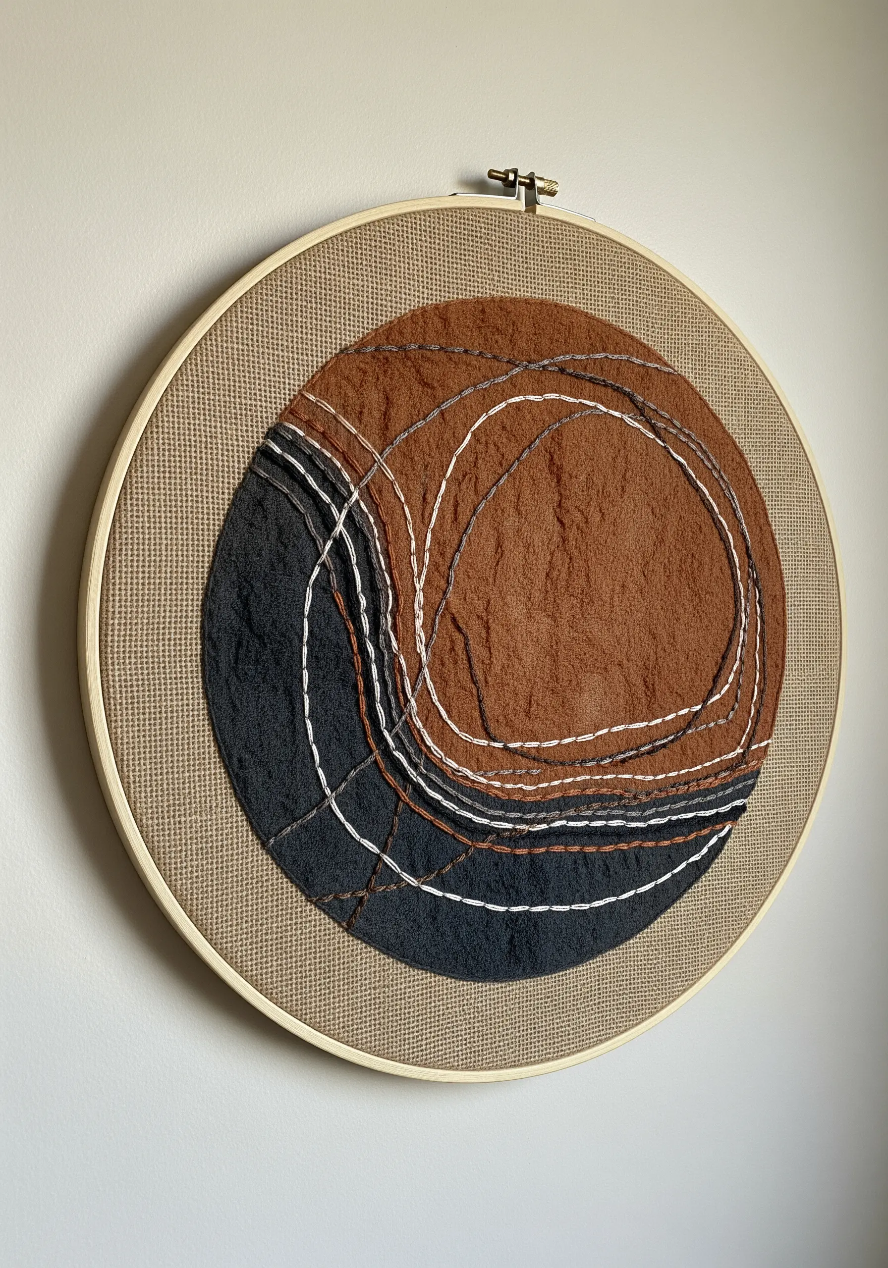 Abstract embroidery hoop art with layered fabric and intersecting lines.