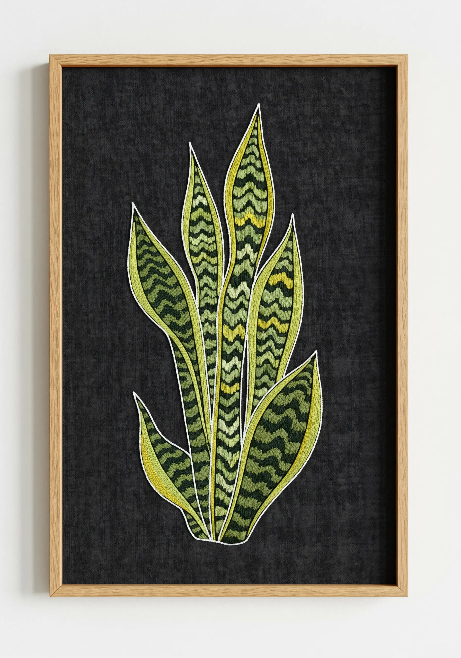 Variegated snake plant embroidered with bright green threads on black fabric.