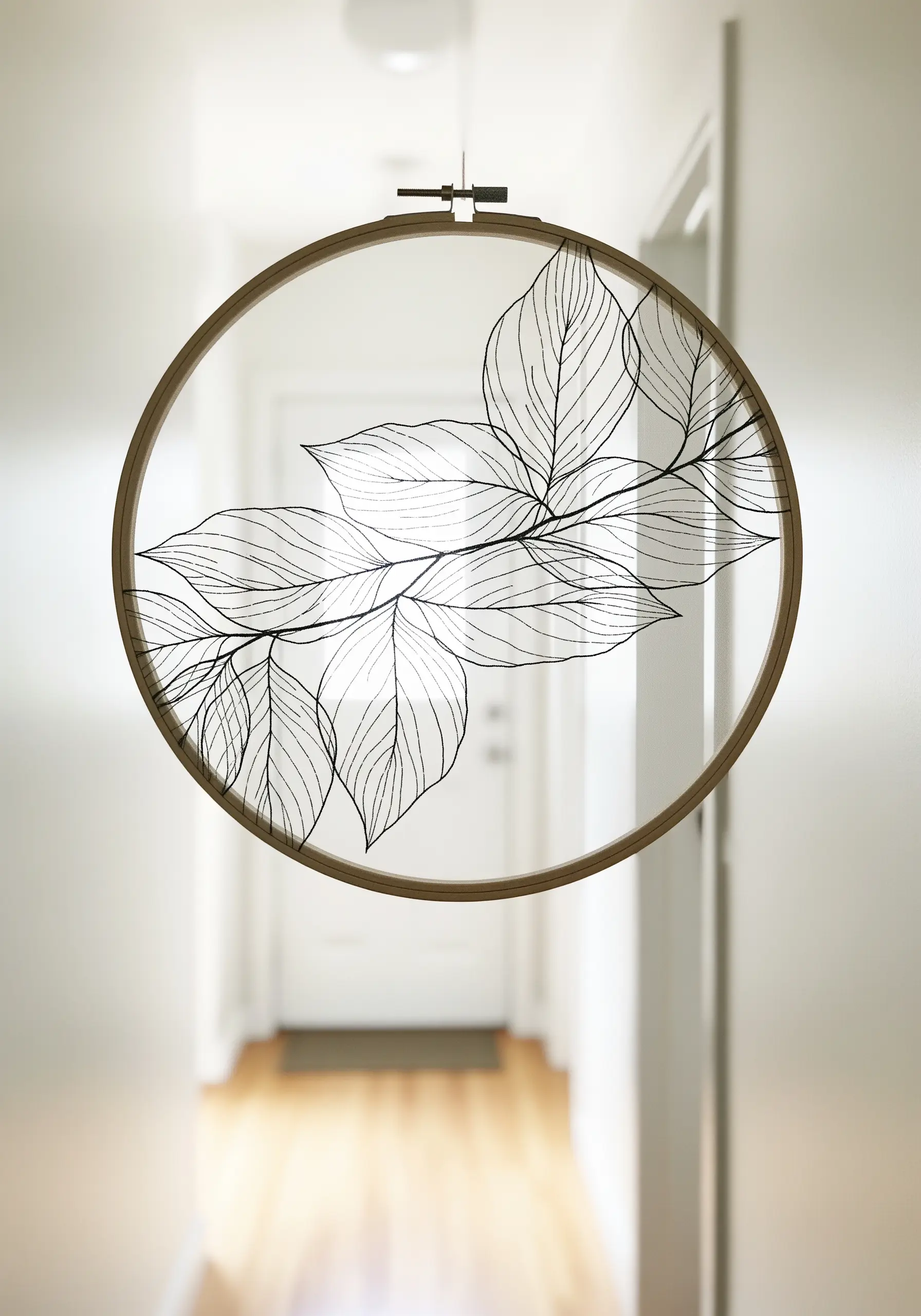 Delicate line-art leaves stitched in black thread on transparent tulle fabric.