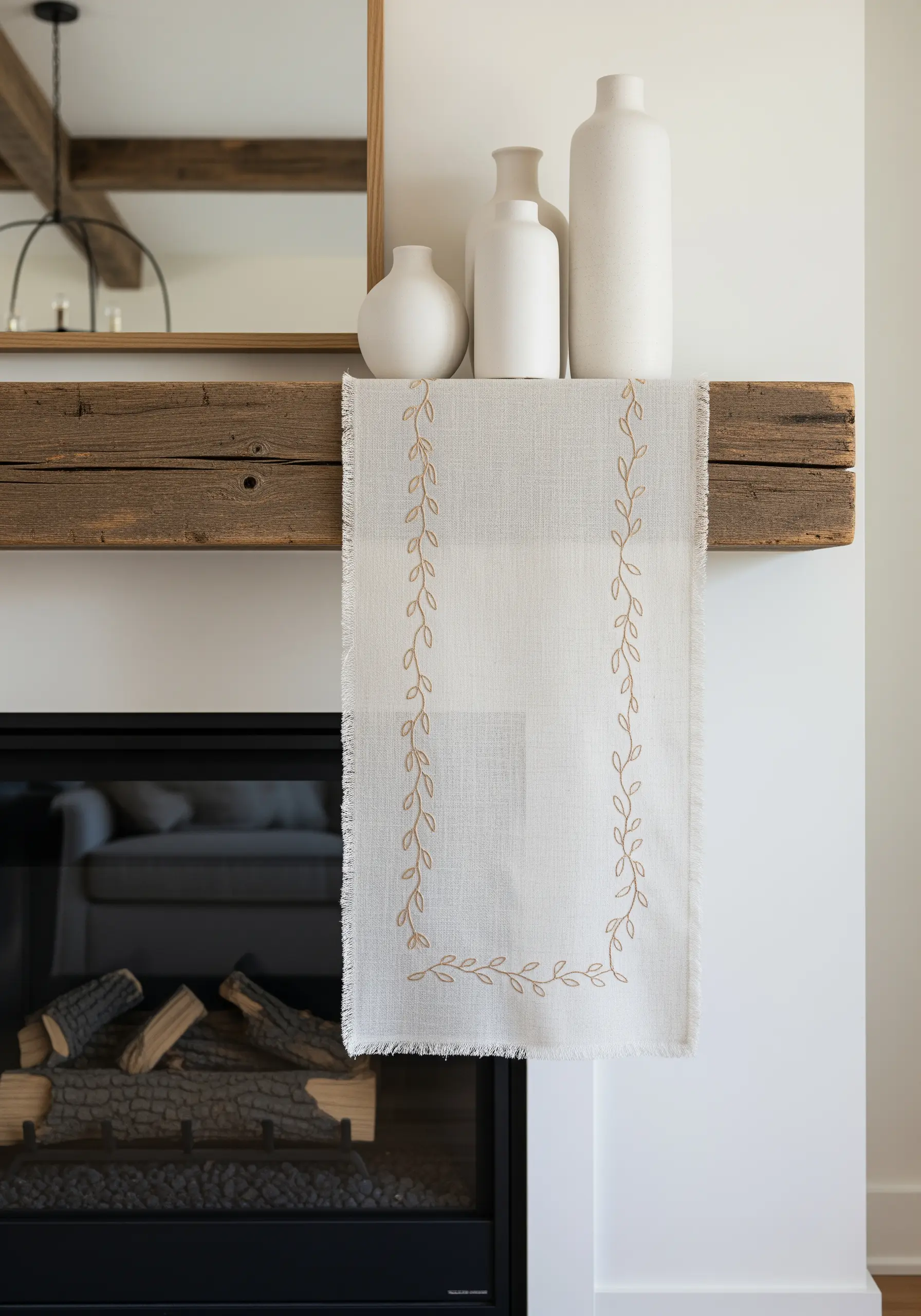 Linen table runner with a delicate, flowing vine border embroidered in a sand color.