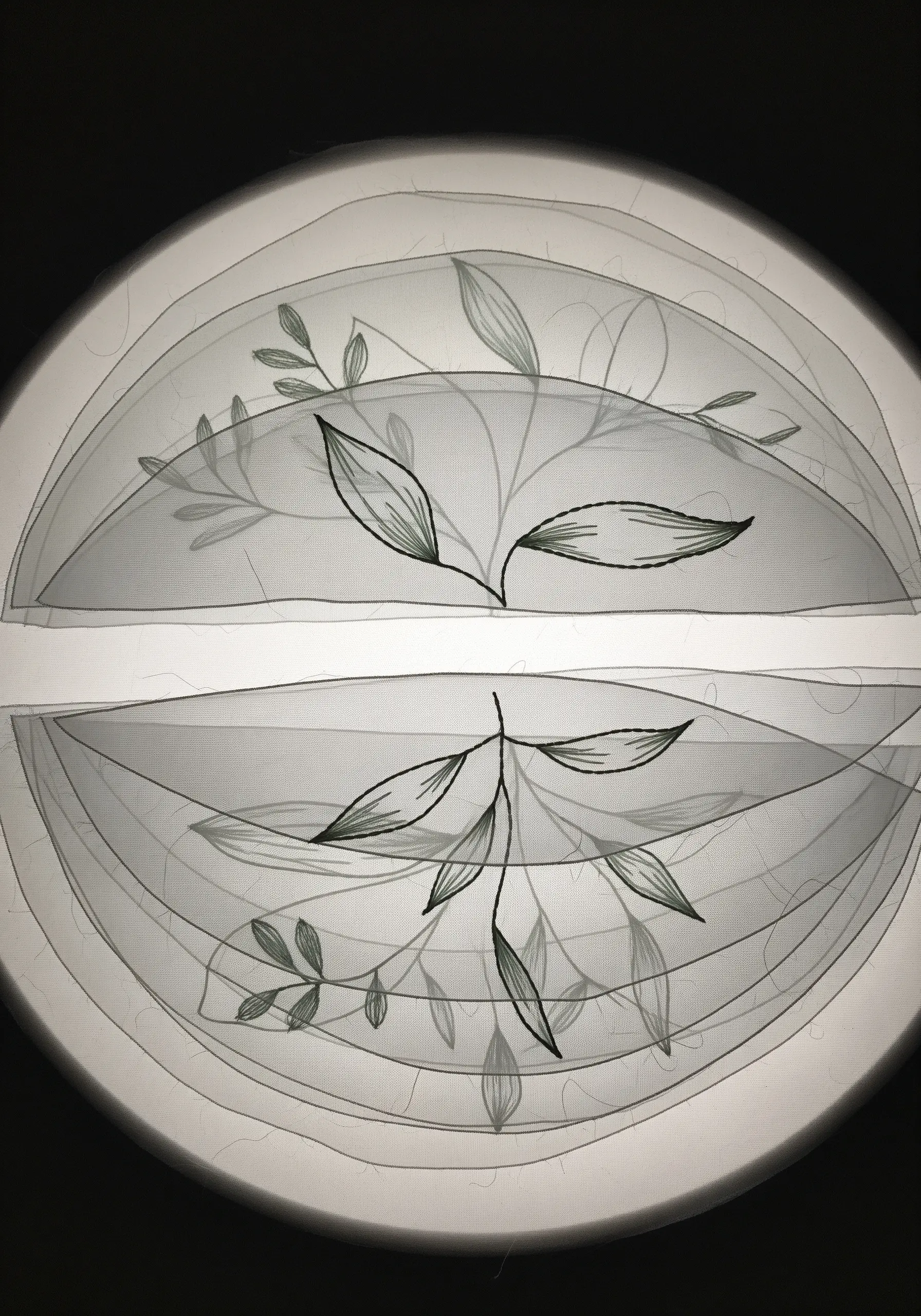 A botanical design stitched through multiple layers of sheer, translucent fabric