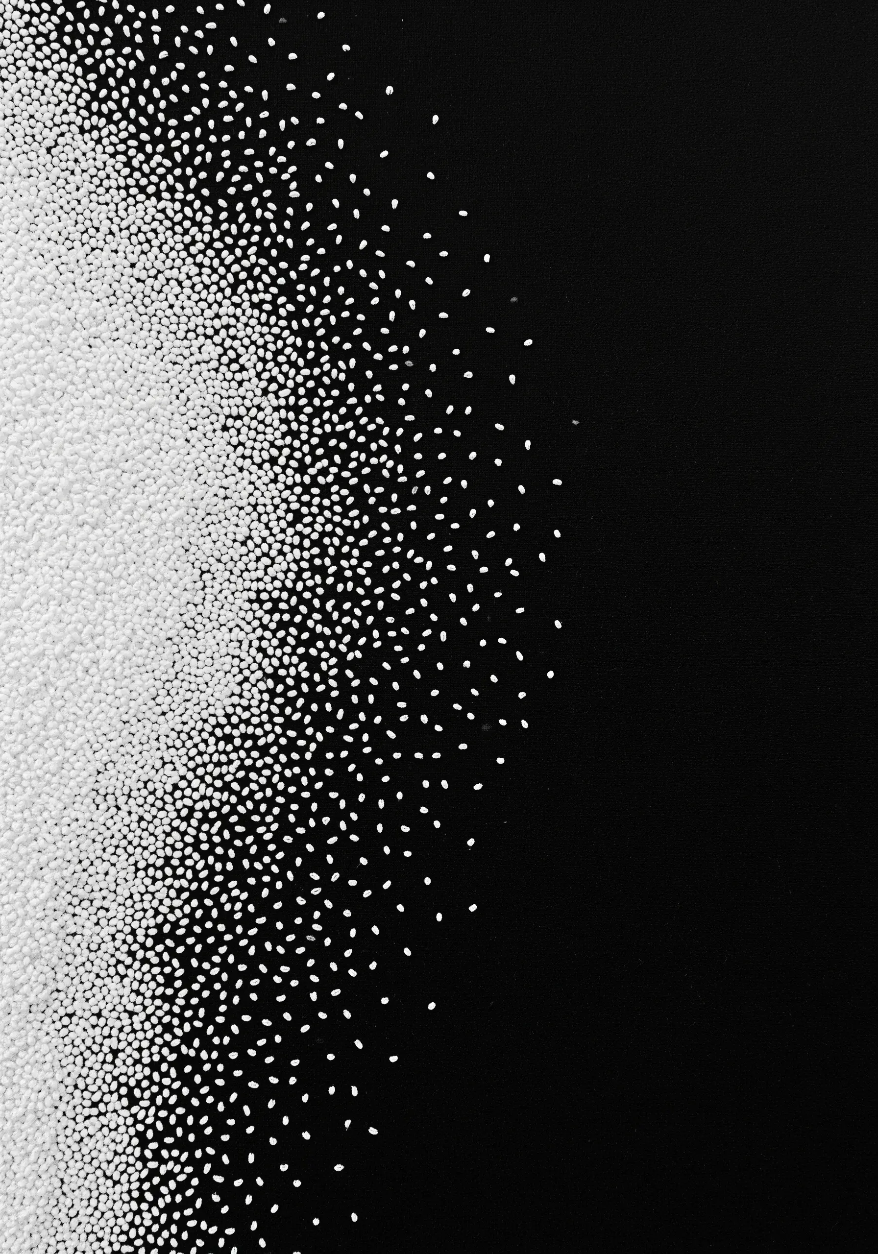 A gradient of tiny white seed beads stitched on black fabric, fading into negative space.