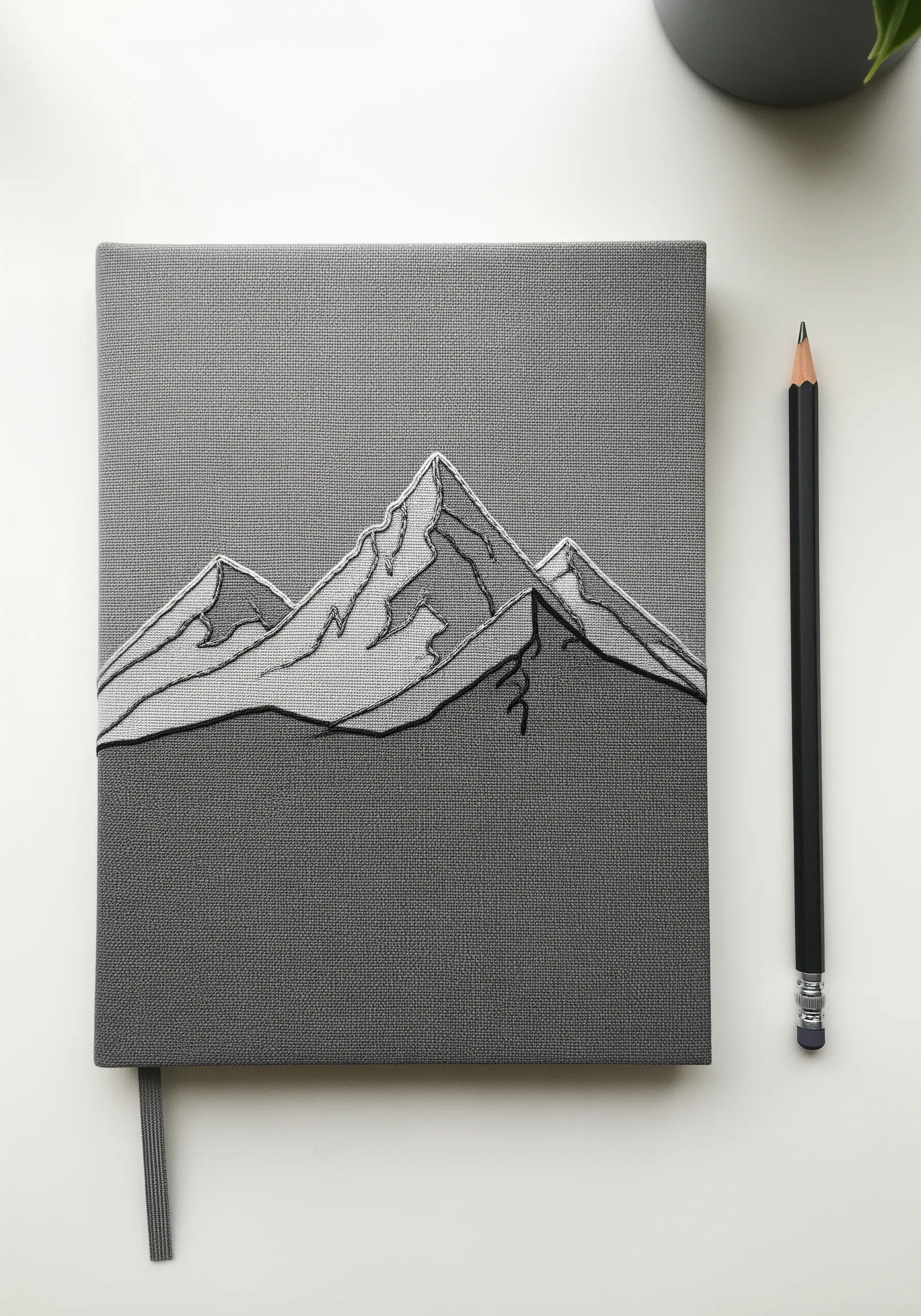 Graphic mountain range embroidered with bold black outlines and grey fill.