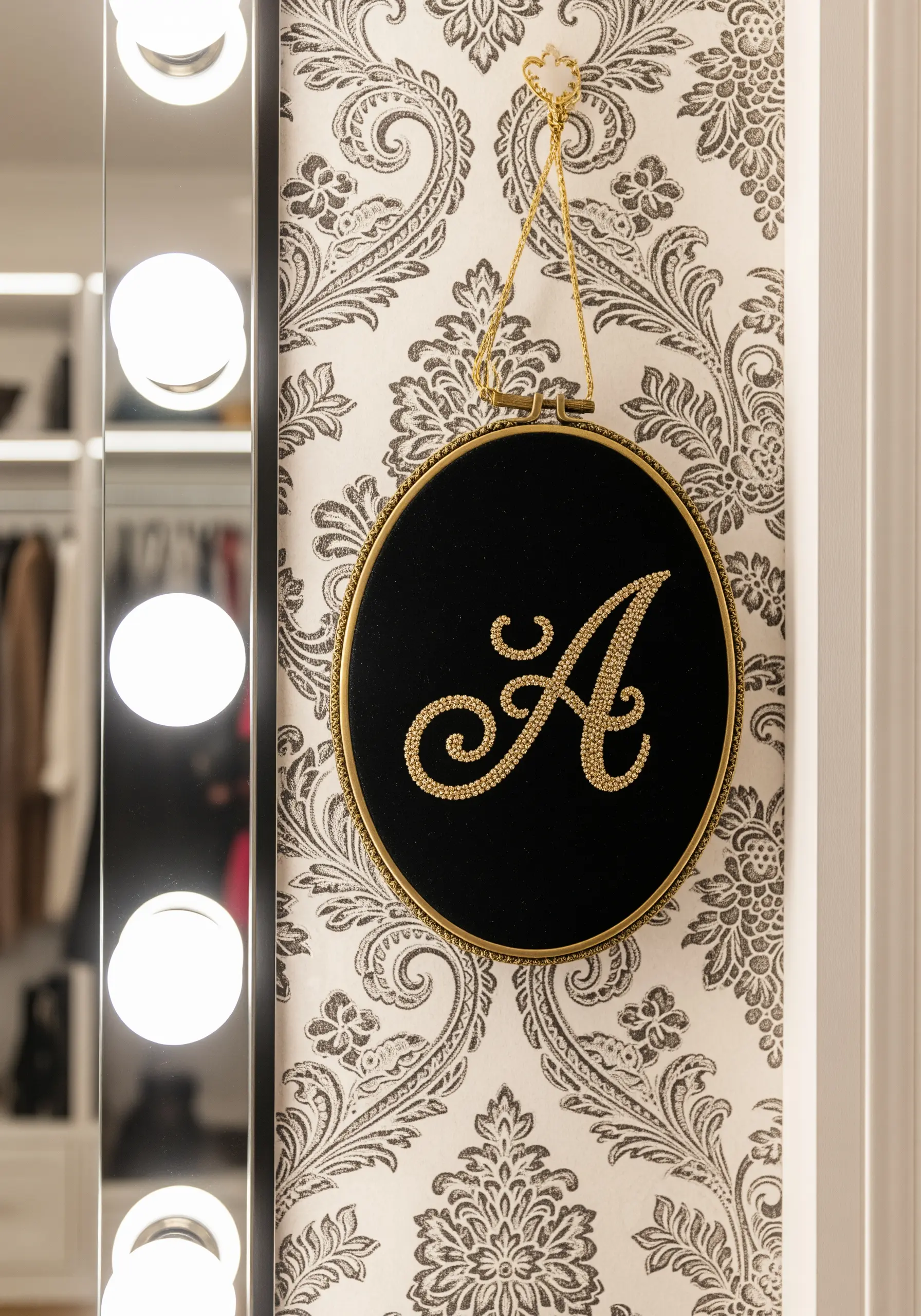 Ornate monogram 'A' created entirely with gold seed beads on black velvet fabric.