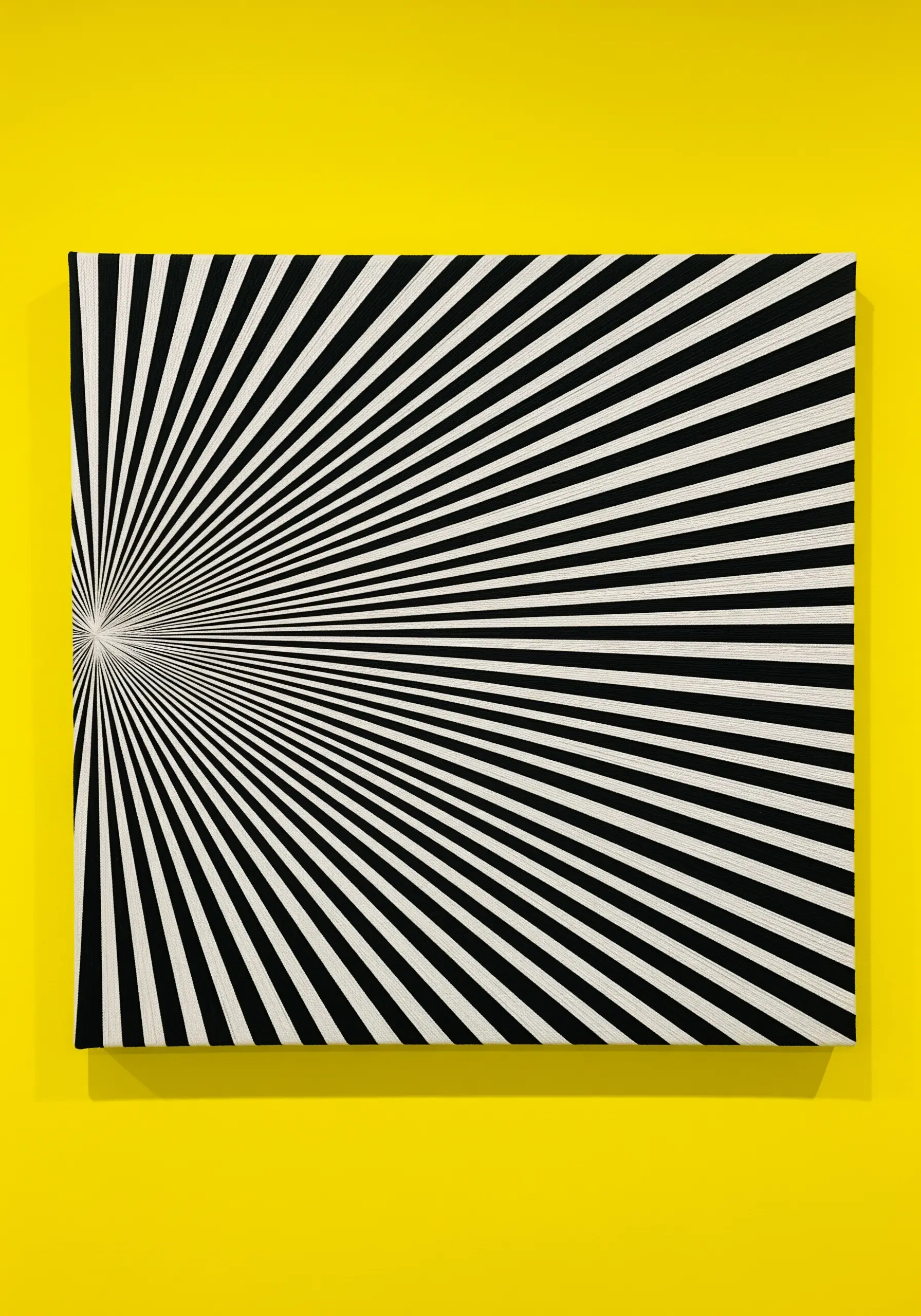 Optical illusion art with radiating black and white lines stitched on a rectangular canvas.
