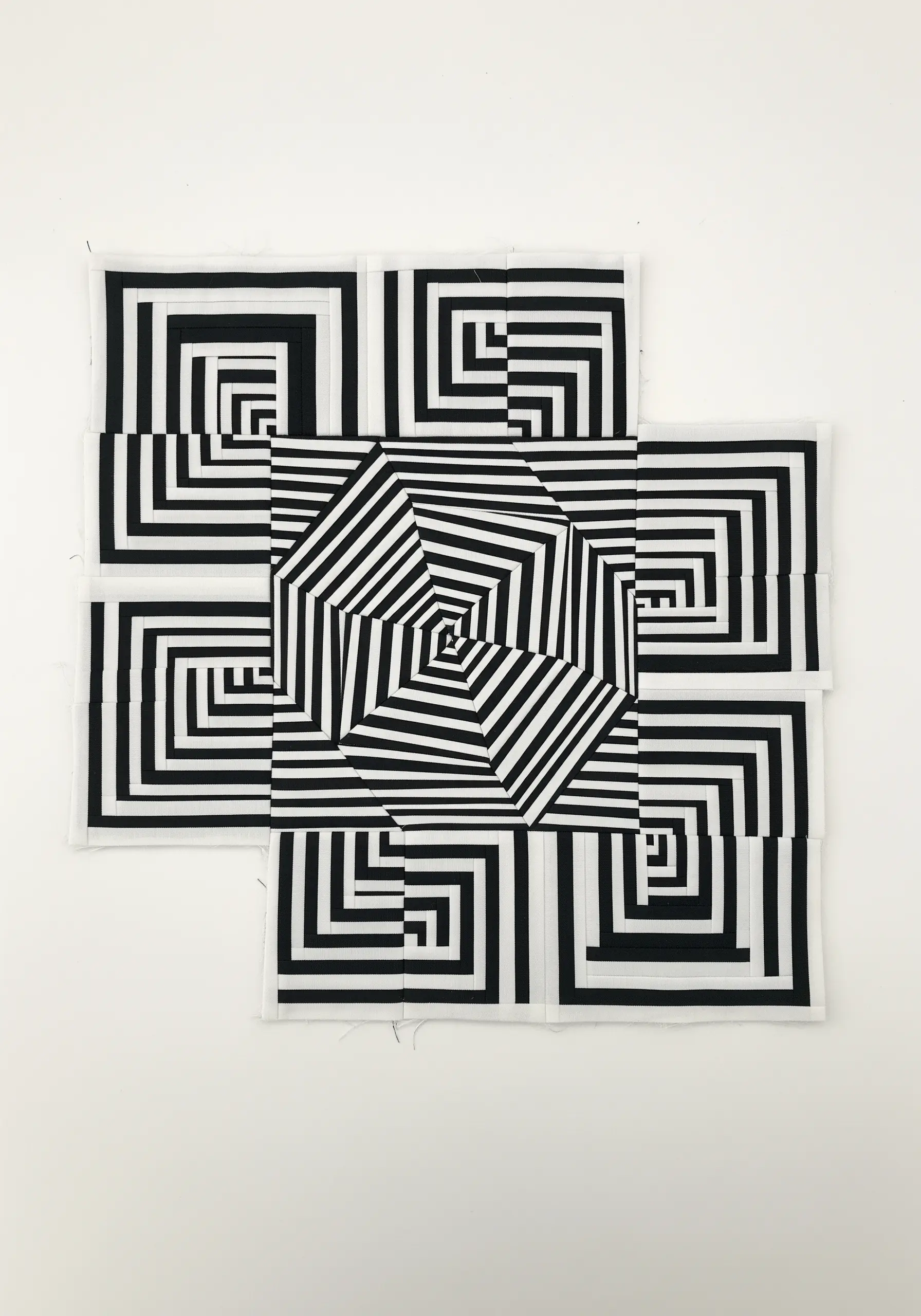 A black-and-white op-art quilt design with geometric shapes creating an optical illusion.
