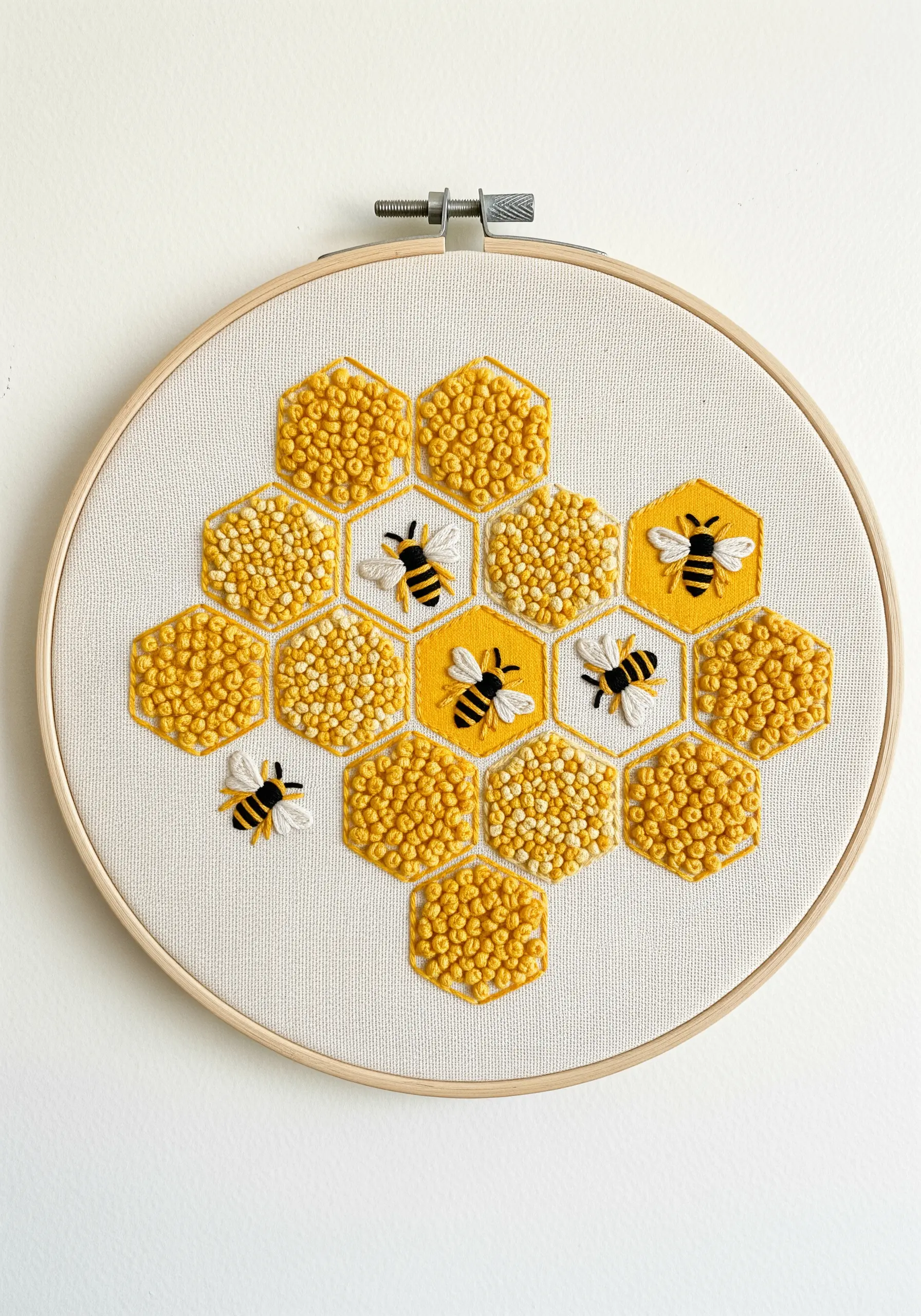 Embroidery of a honeycomb pattern, with the cells filled with yellow and white French knots.