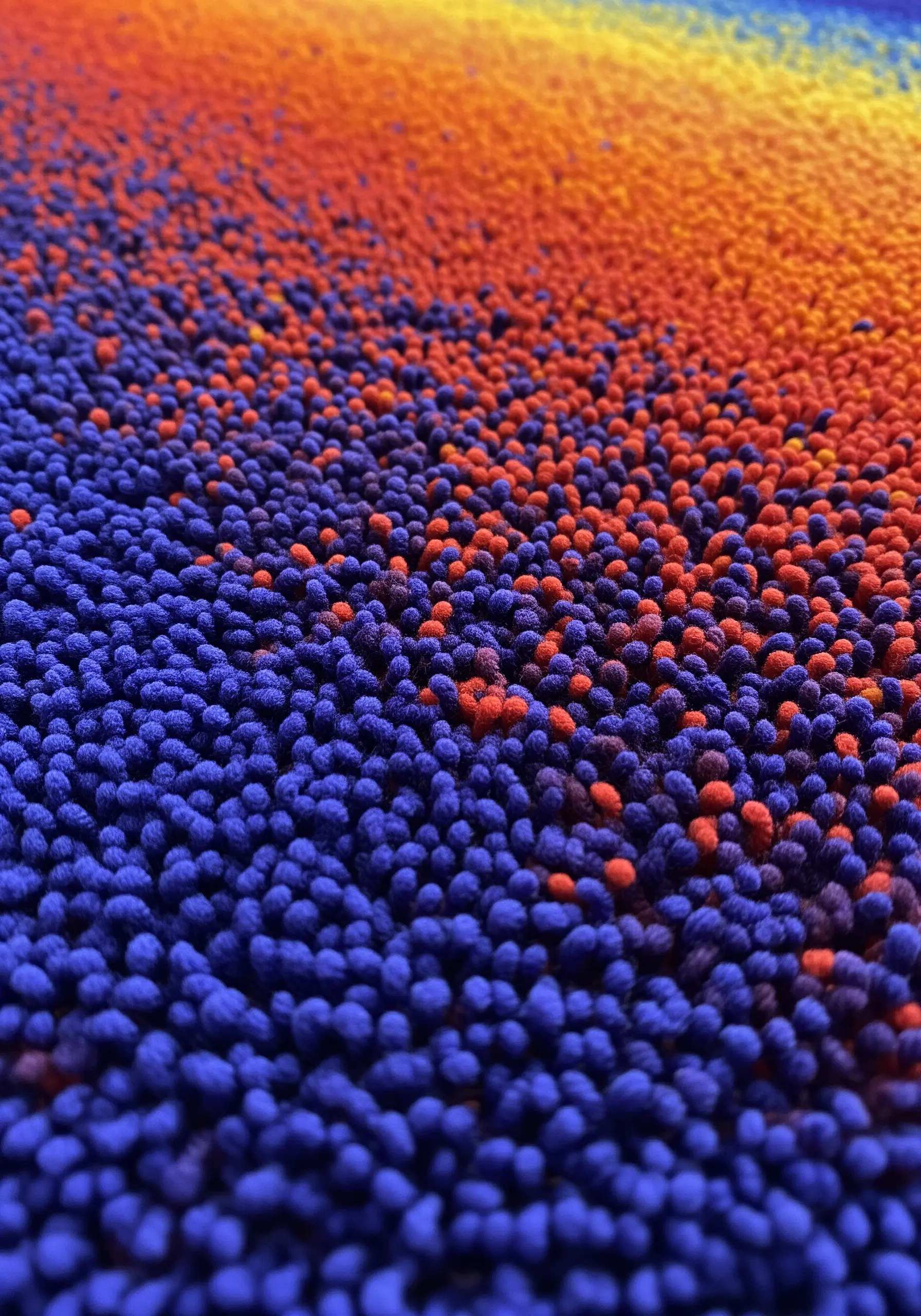 Dense field of blue and orange French knots creating a textured color gradient.