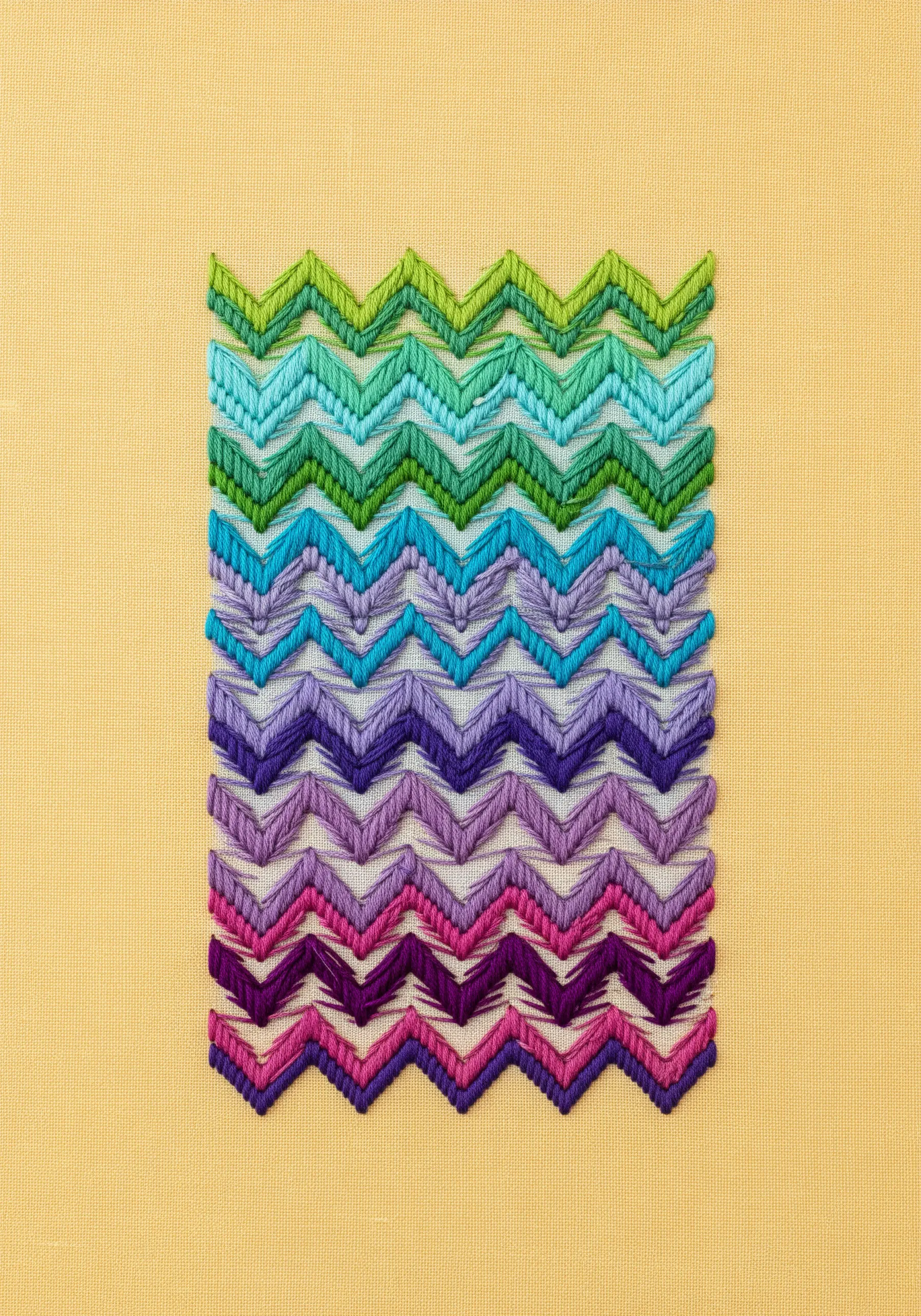 A block of chevron stitches transitioning in a gradient from green to purple.