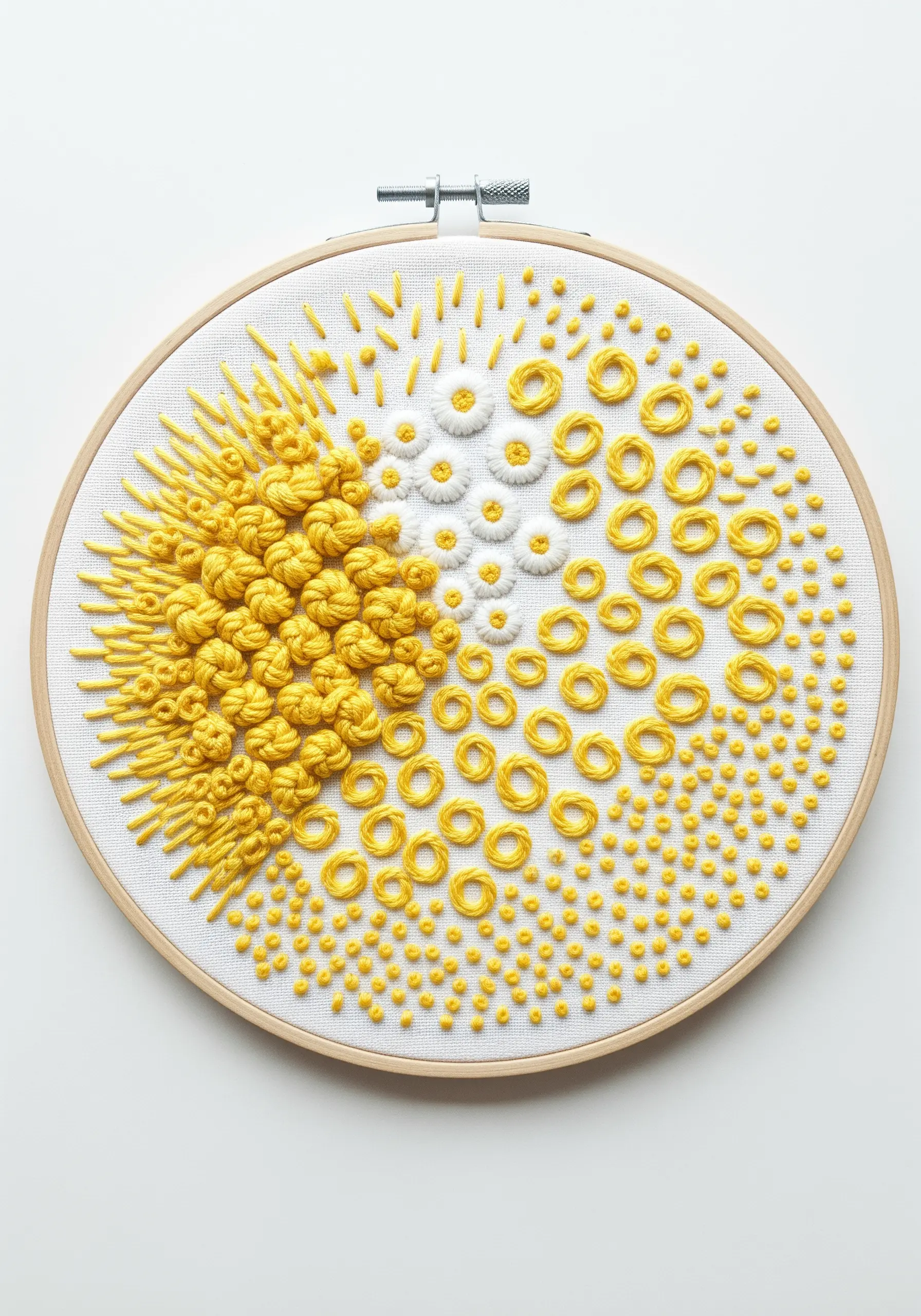 Embroidery hoop showing a textural gradient from dense yellow knots to sparse white stitches.