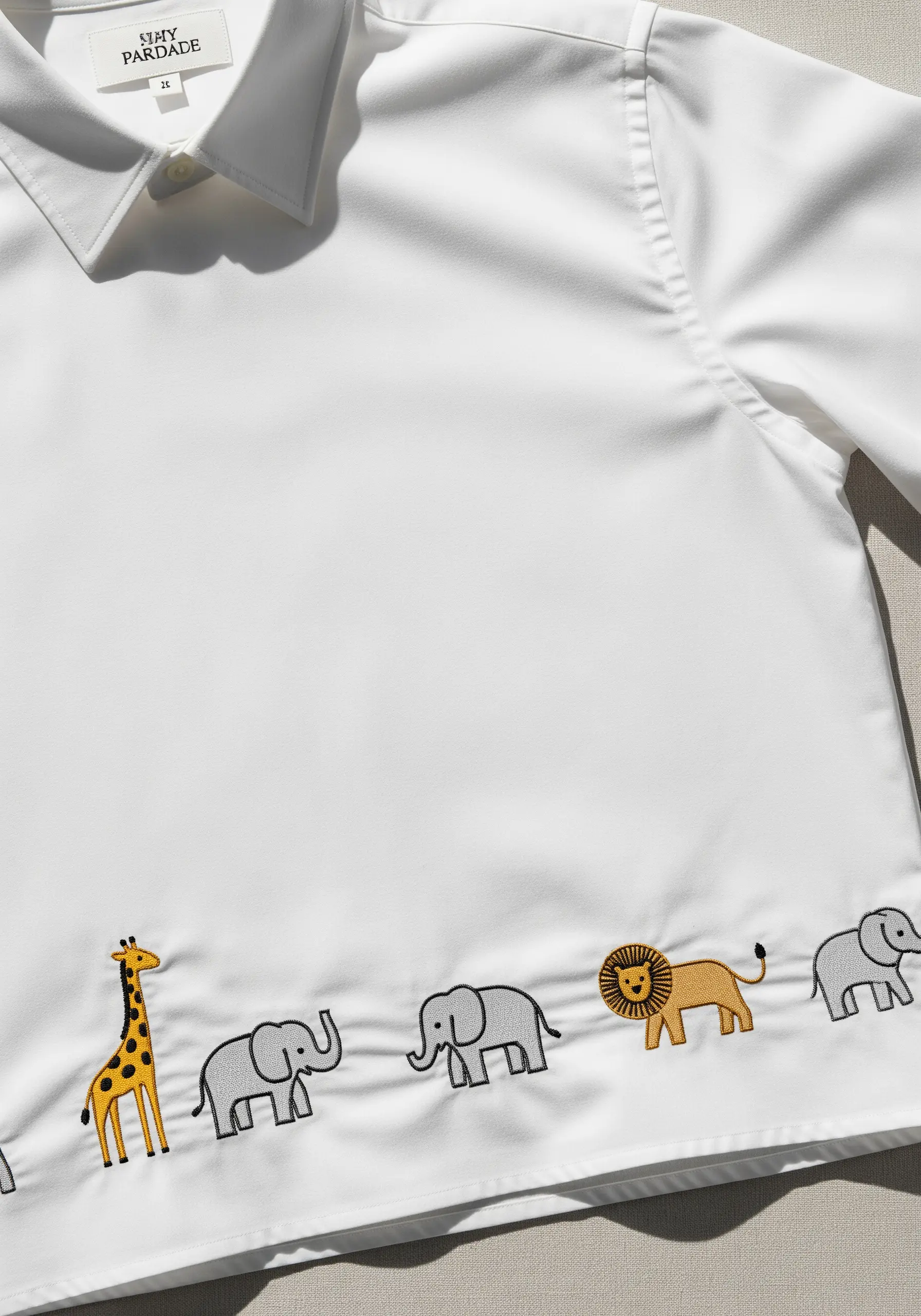 A parade of embroidered safari animals along the hem of a white shirt.