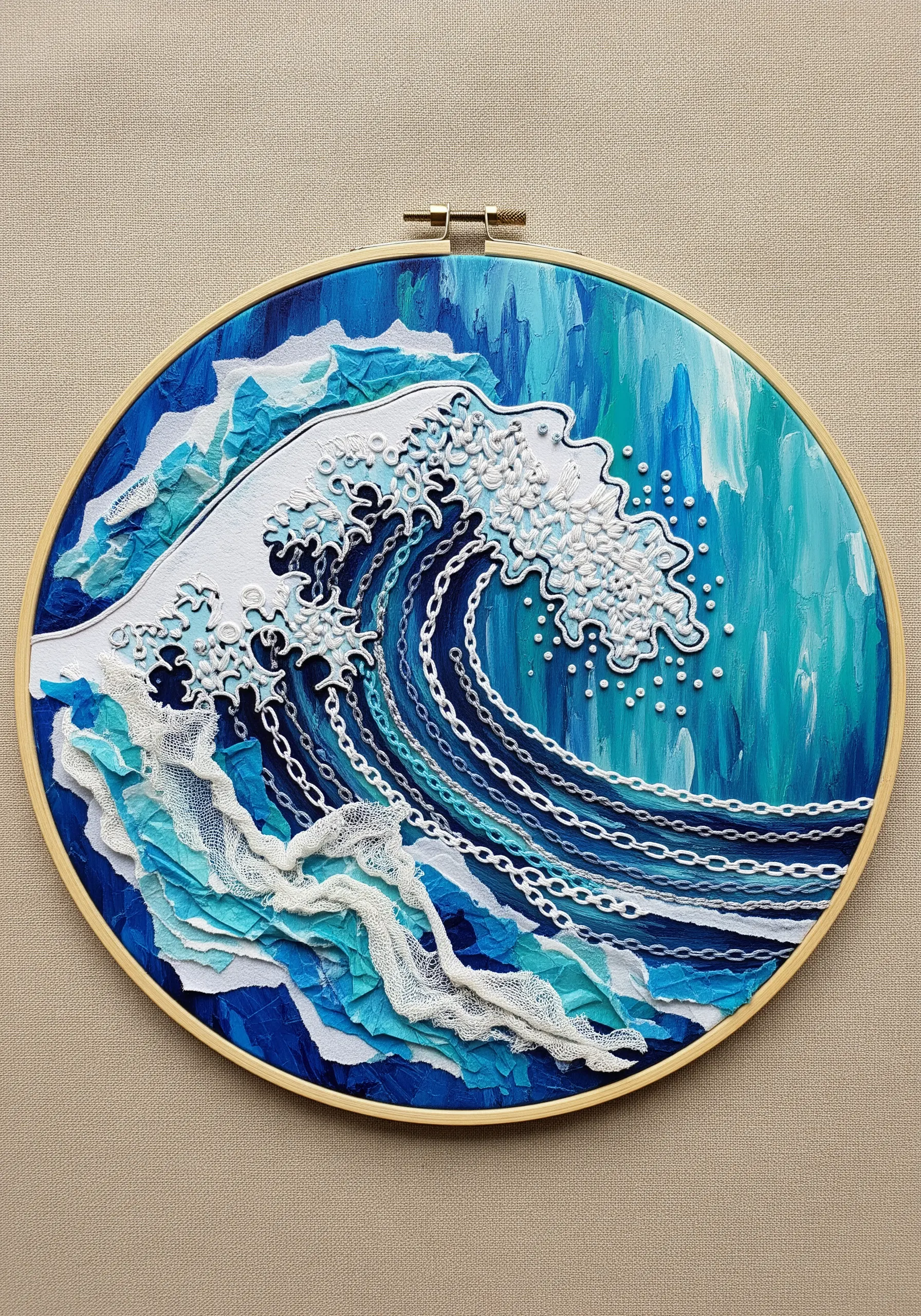 Mixed-media wave in a hoop using torn paper, lace, and white French knots for sea foam.
