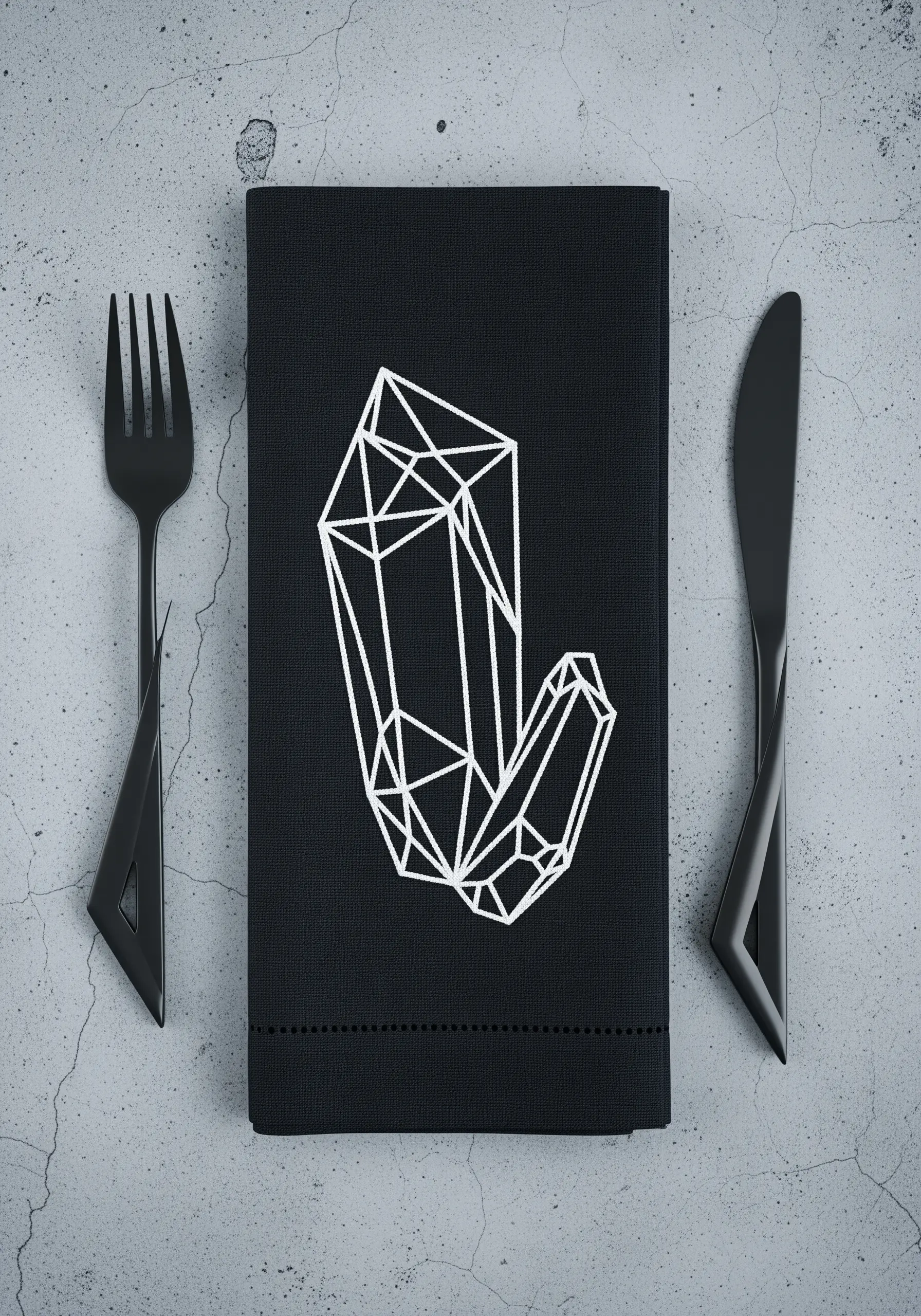 Geometric crystal cluster embroidered in white line art on a black napkin.