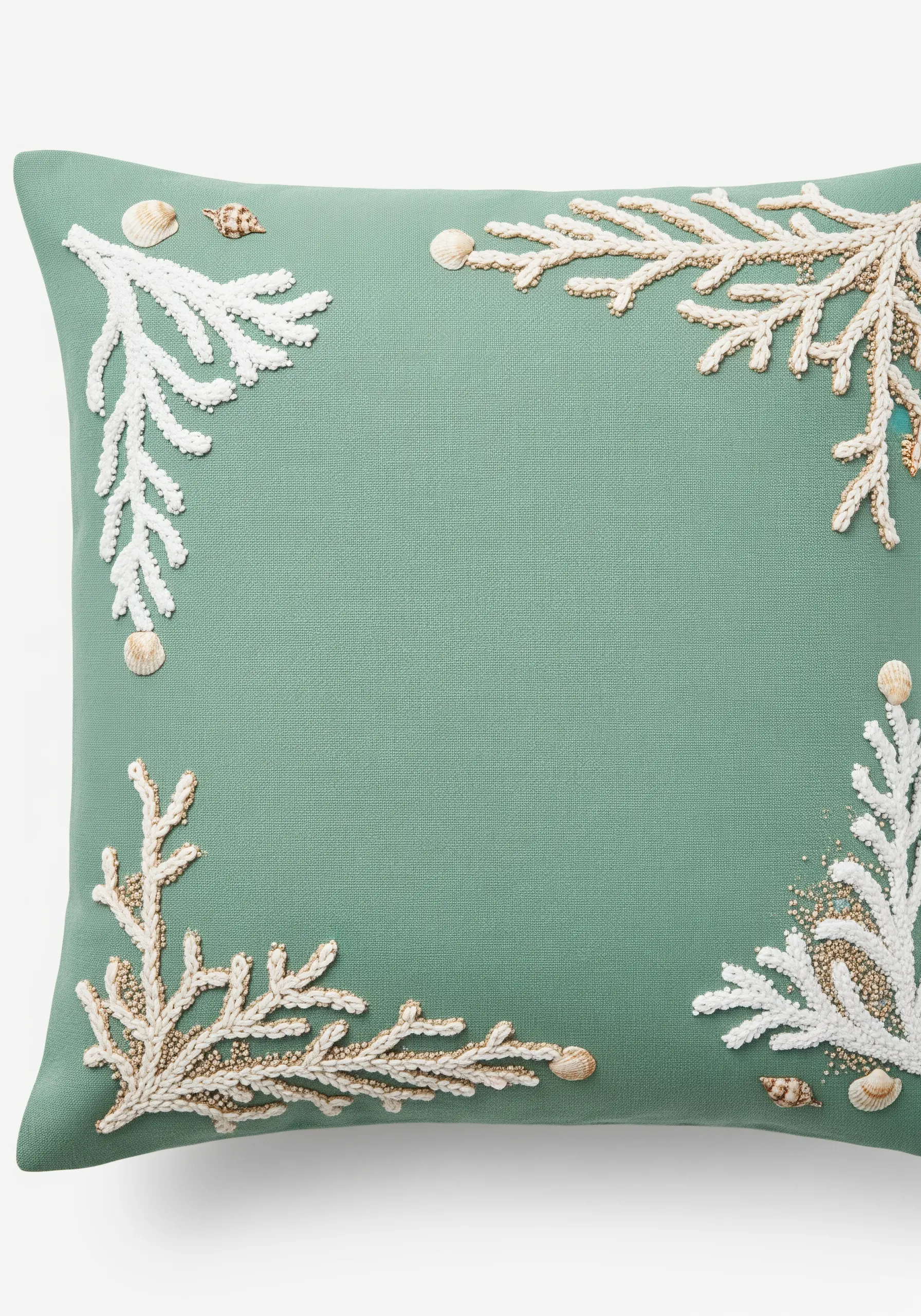 A coastal-themed cushion with coral branches made from white French knots and gold beads