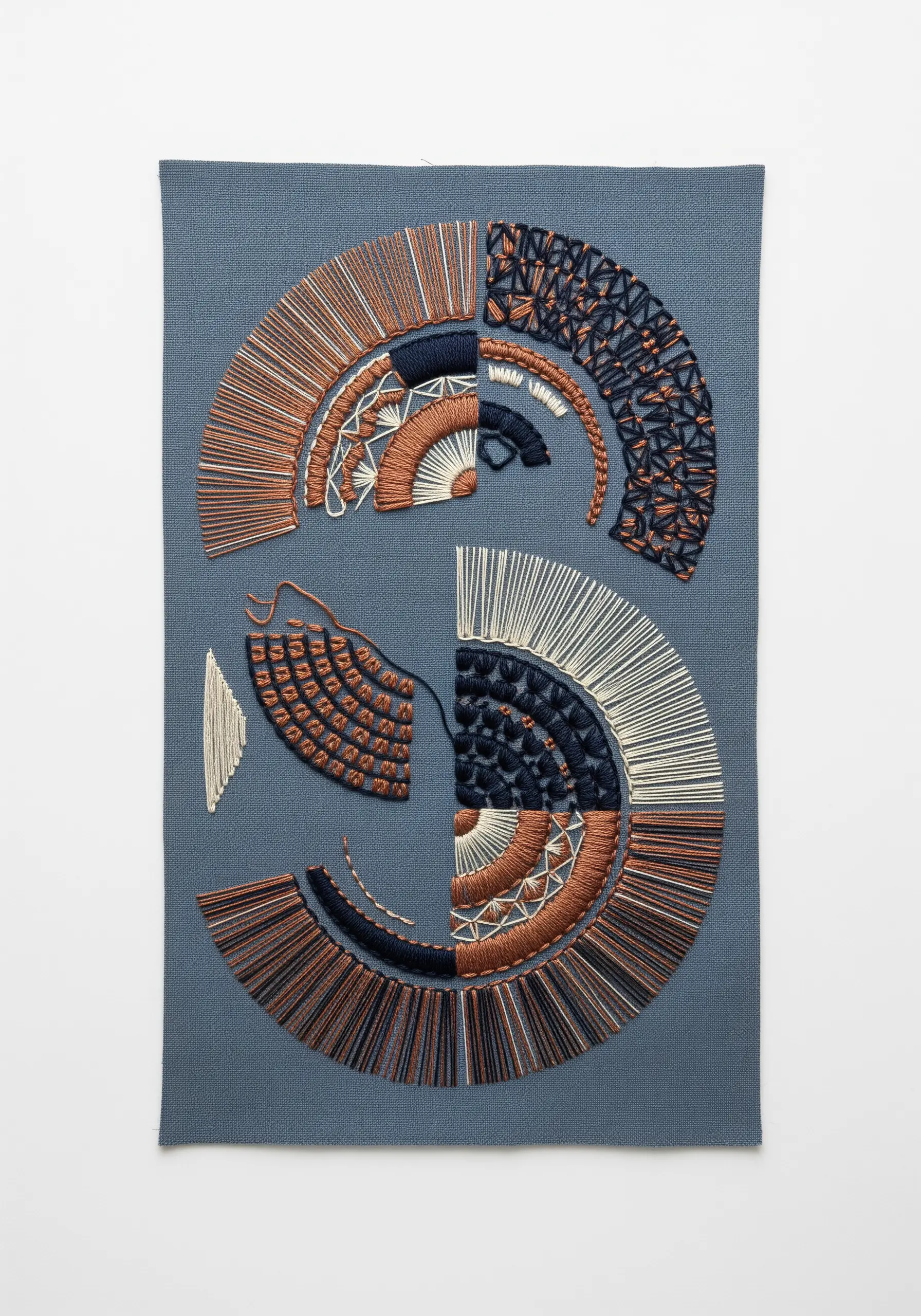 Abstract, deconstructed S-shaped mandala in copper, navy, and white on blue fabric.