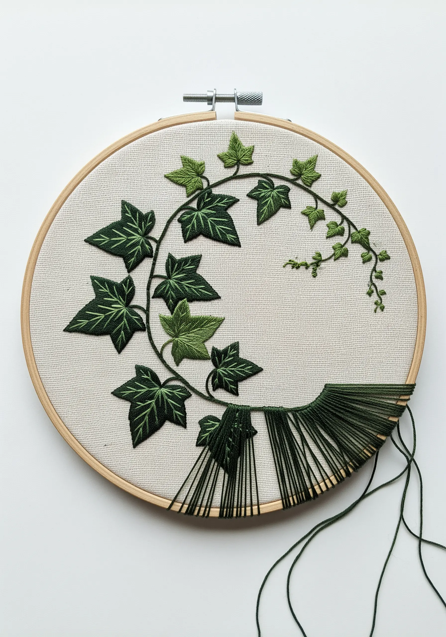 An ivy vine that dissolves from stitched leaves into long, straight, loose threads.