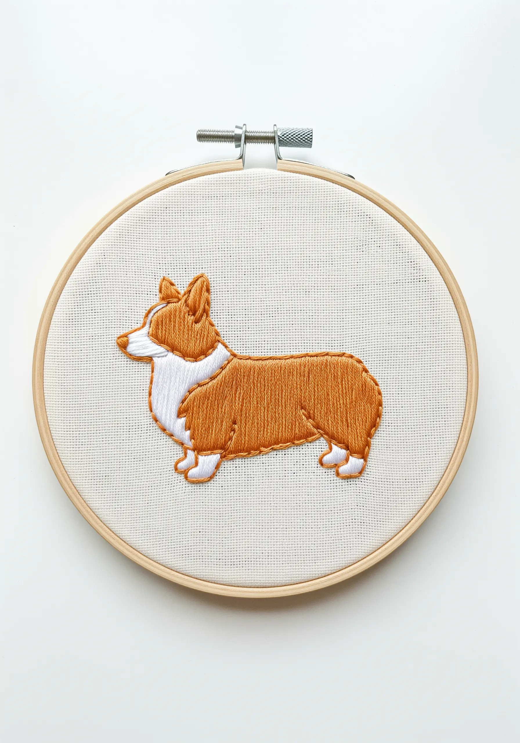 A corgi embroidered with clean blocks of satin stitch in orange, white, and tan.