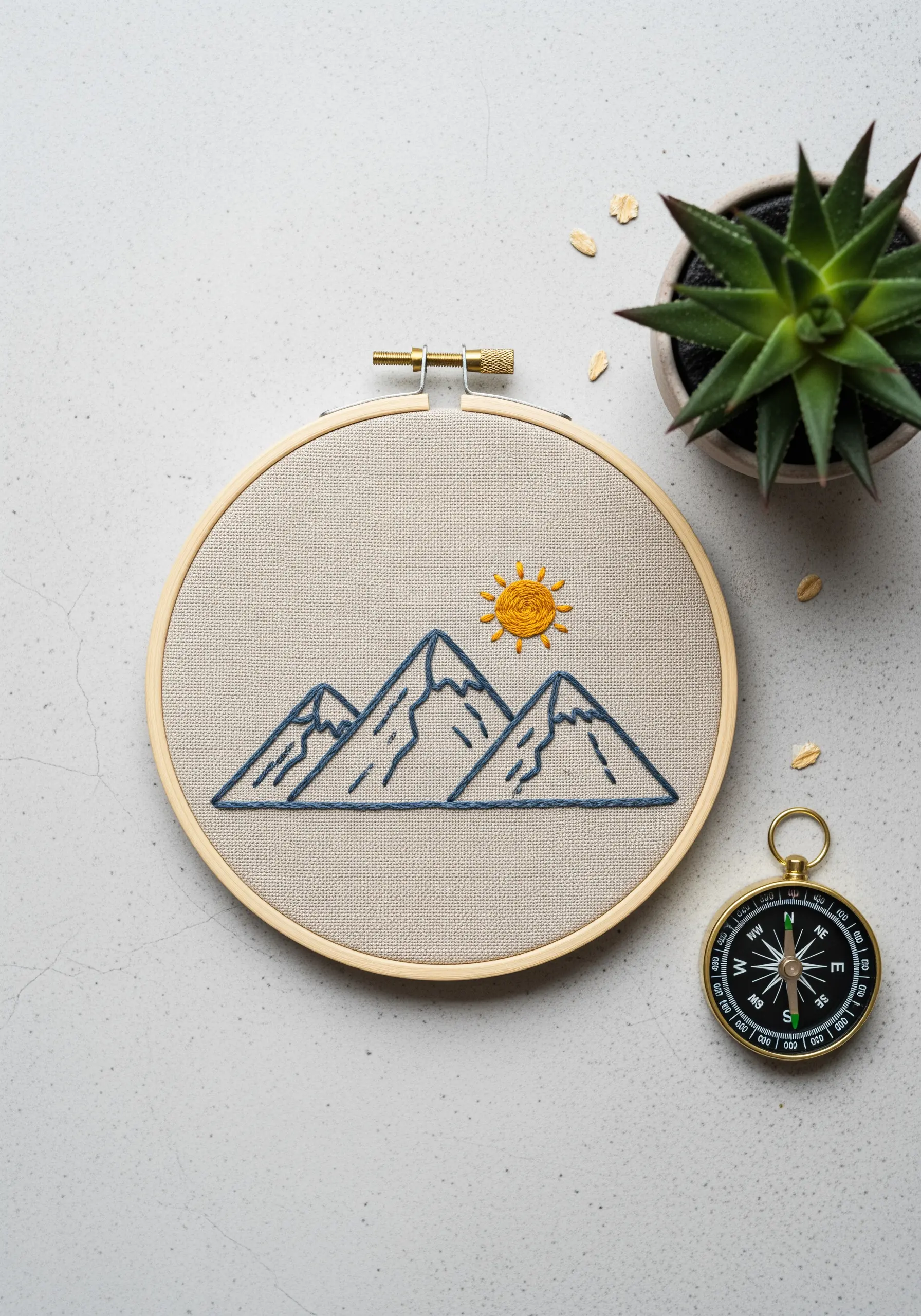 Minimalist mountain range outline embroidered in a hoop with a single blue thread.