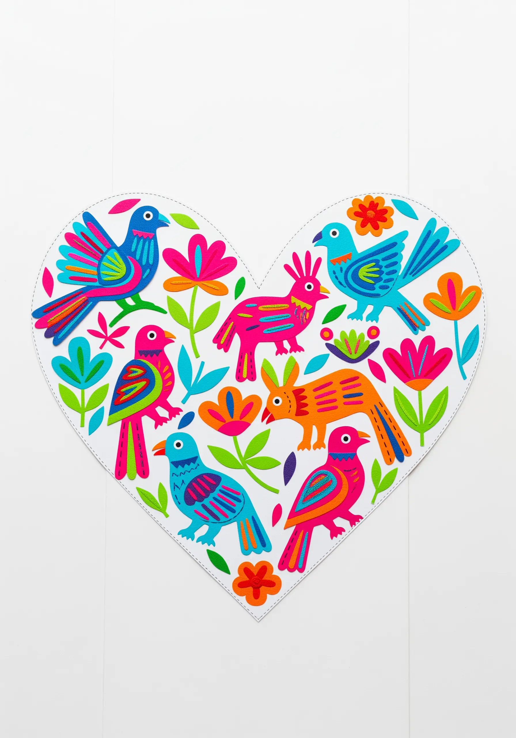 A heart-shaped paper collage filled with colorful folk art birds and flowers.