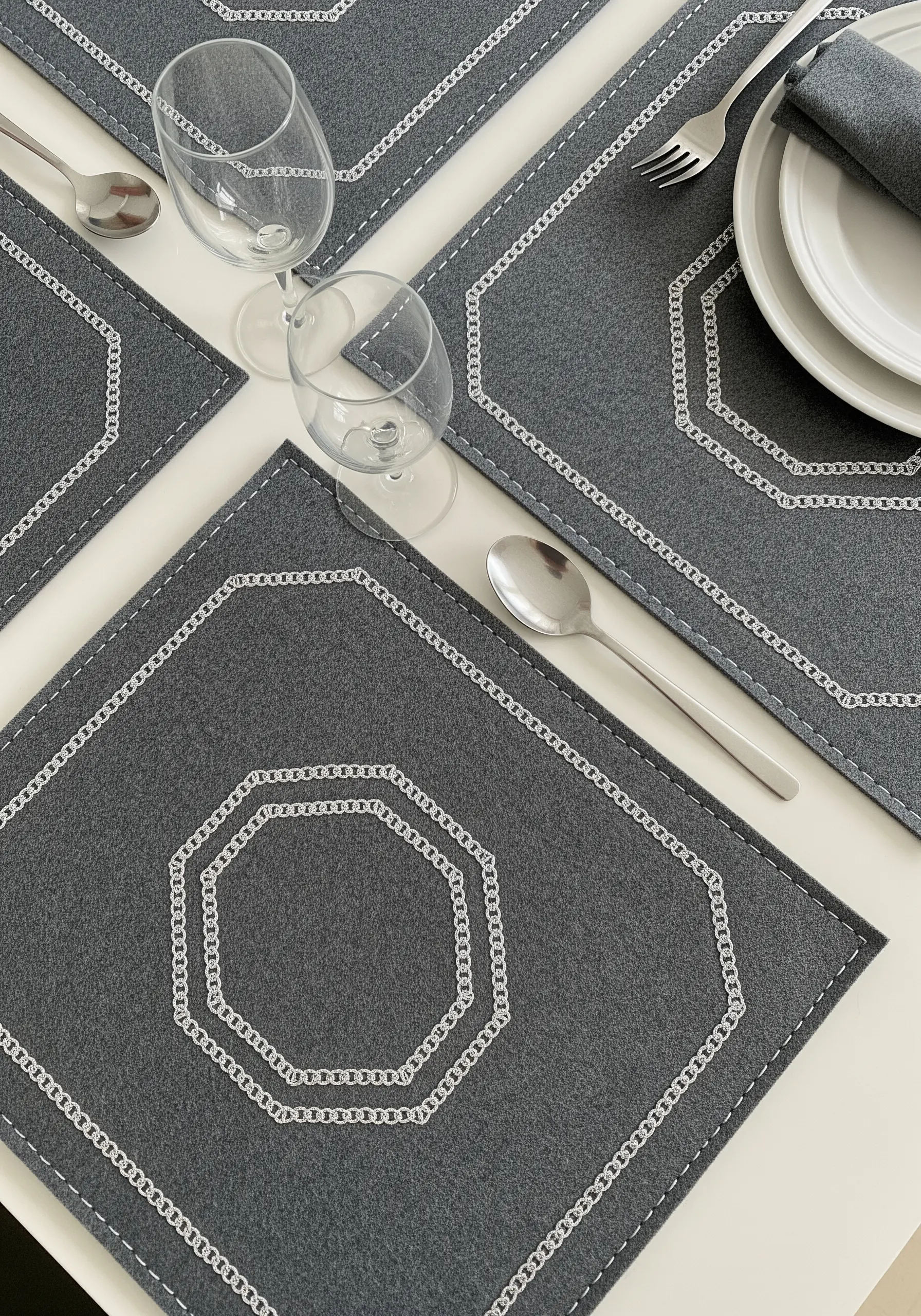 Grey placemats with a silver chain stitch border forming an octagonal shape.