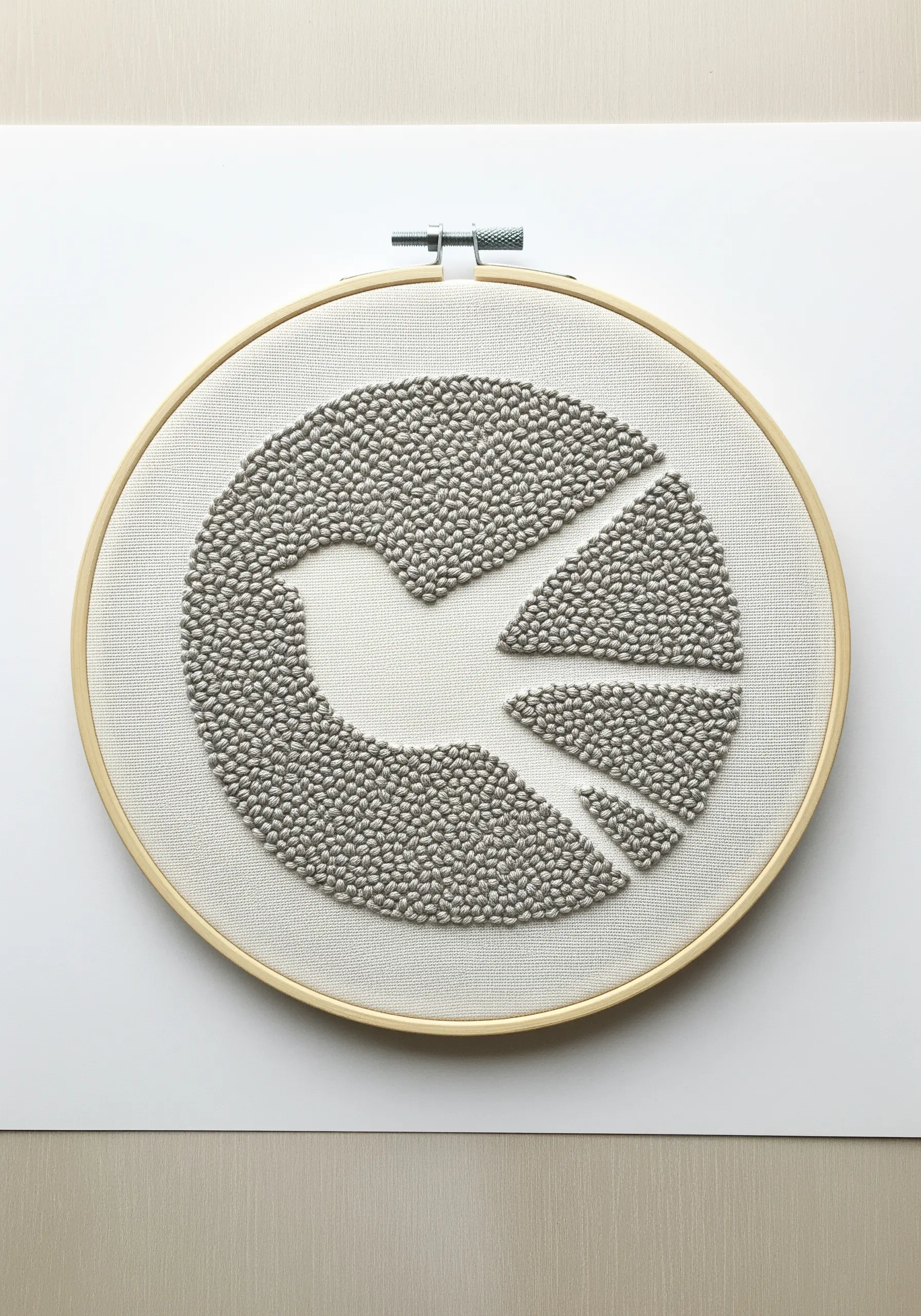 A dove silhouette created with negative space, surrounded by dense grey French knots.