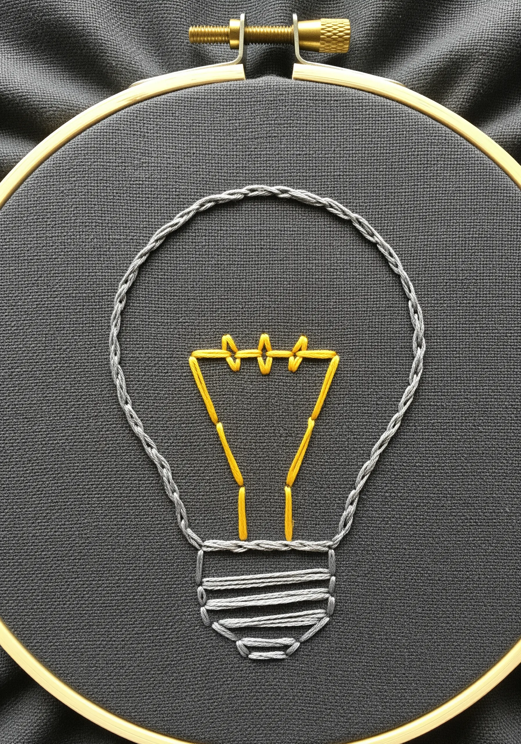 Line art lightbulb using a thick chain stitch and thin backstitch.