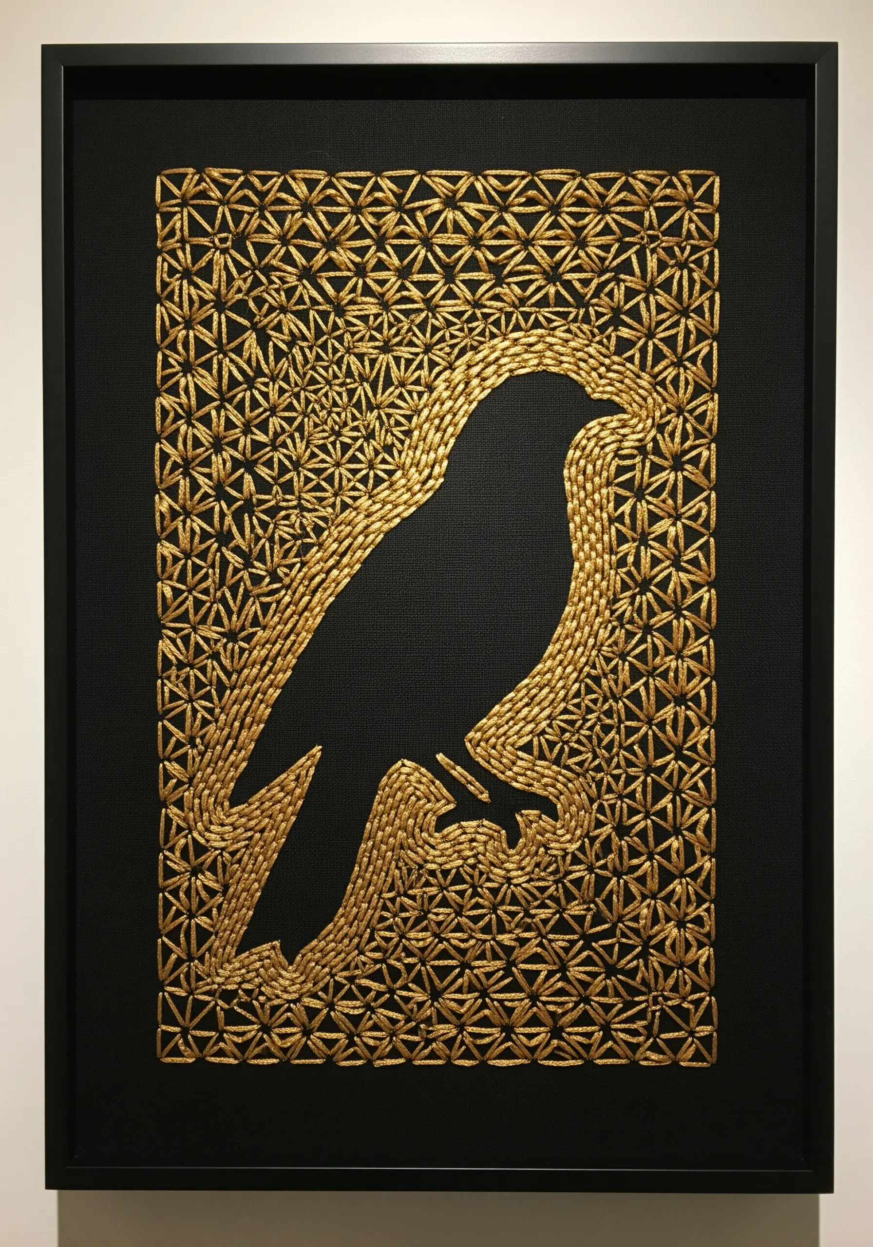 A black bird silhouette created by a negative space effect against a gold geometric fill stitch.