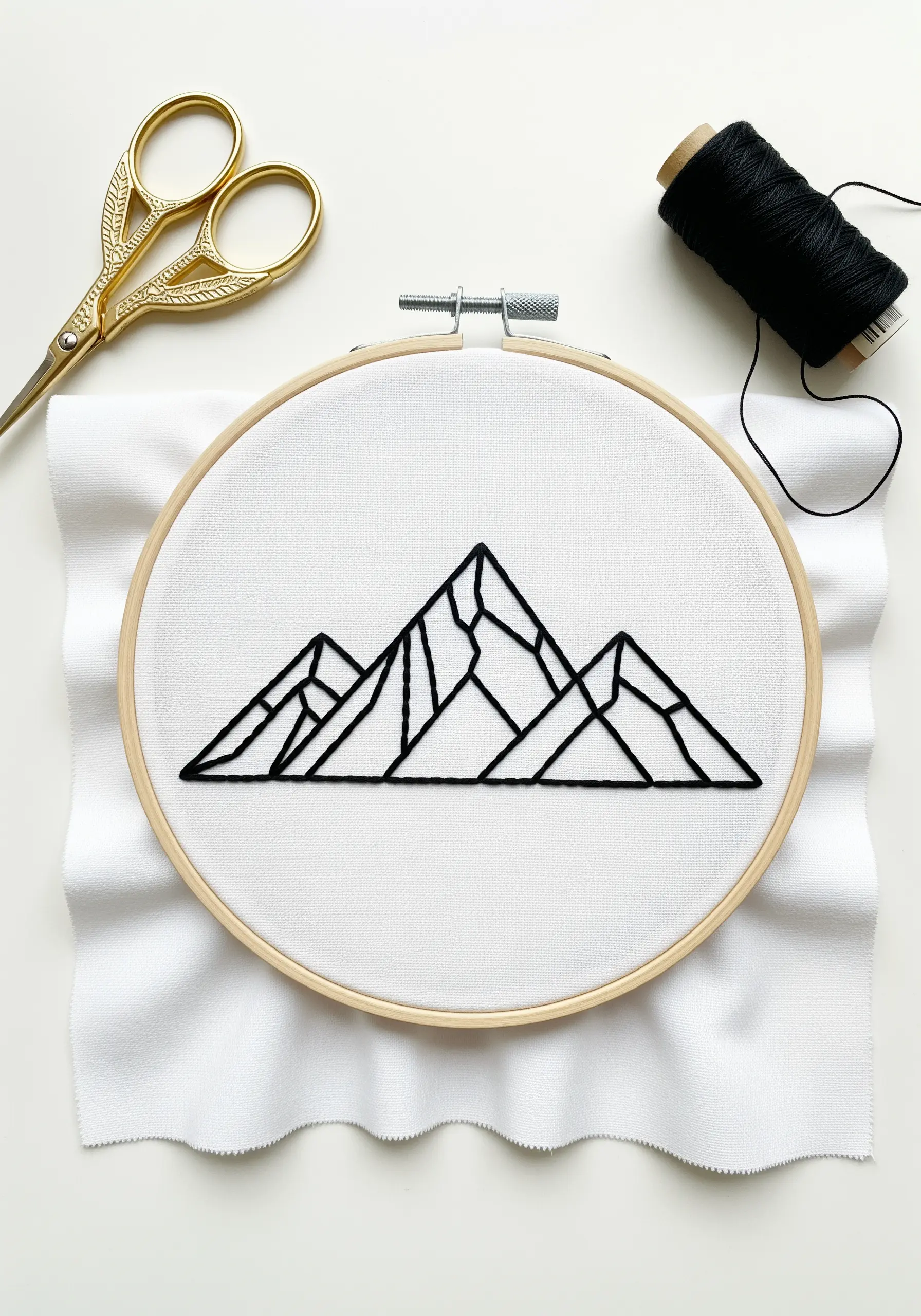 A bold geometric mountain range outlined in black thread on white fabric.