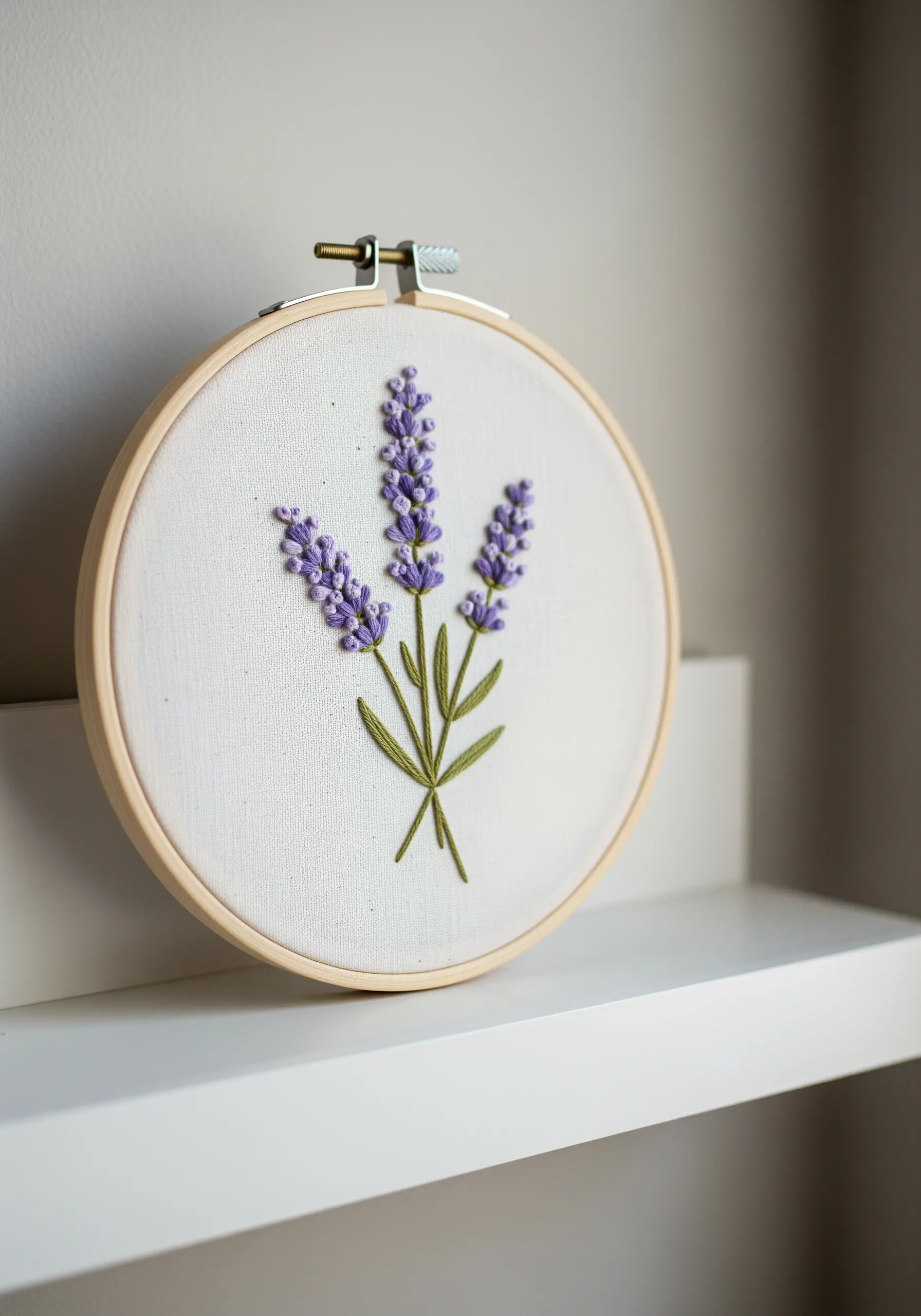 Three embroidered lavender sprigs with purple French knot flowers on white fabric.