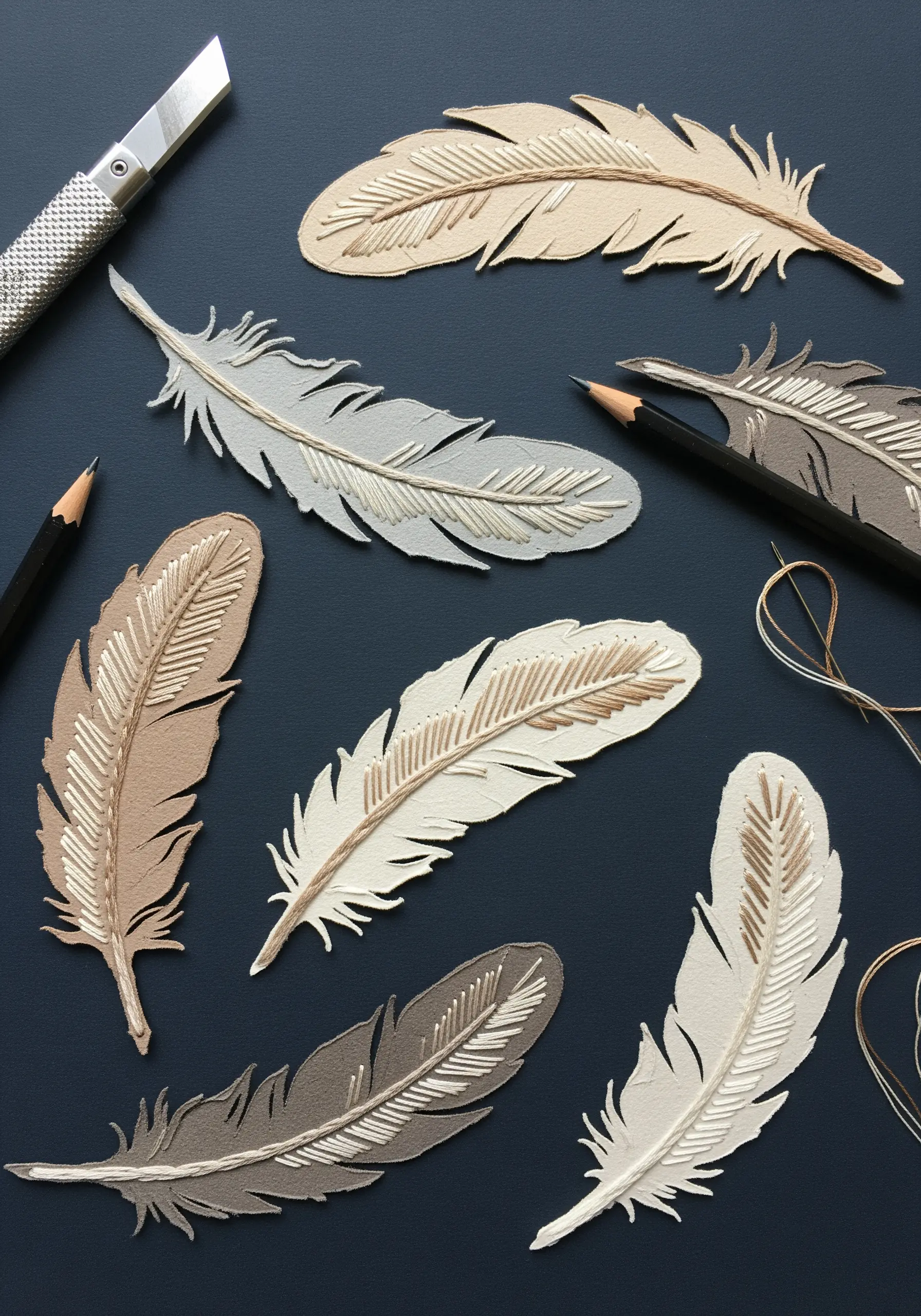 Paper cutout feathers with delicate straight stitch and stem stitch details.