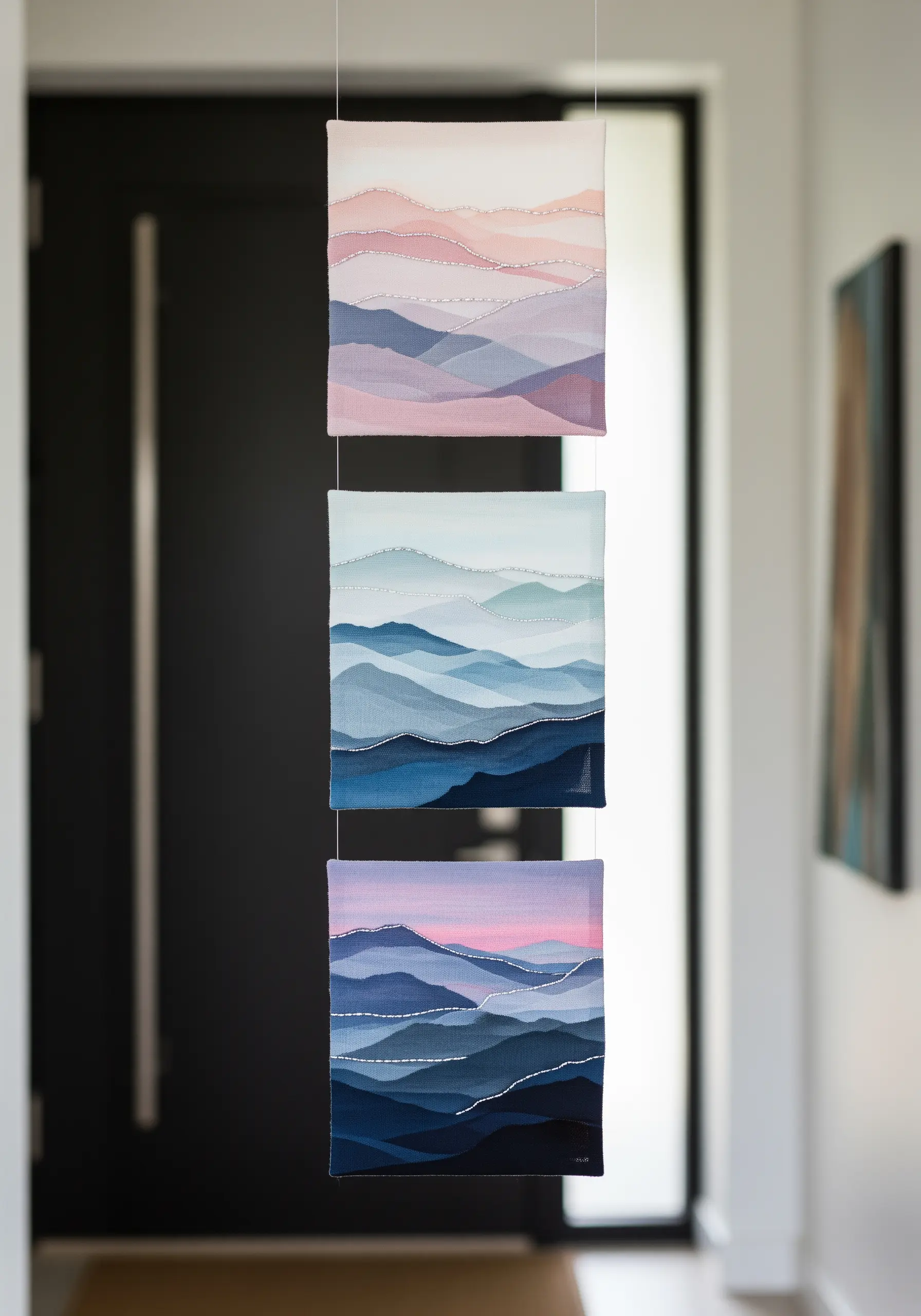 A triptych of three fabric collages showing layered sheer mountain ranges in different color palettes.