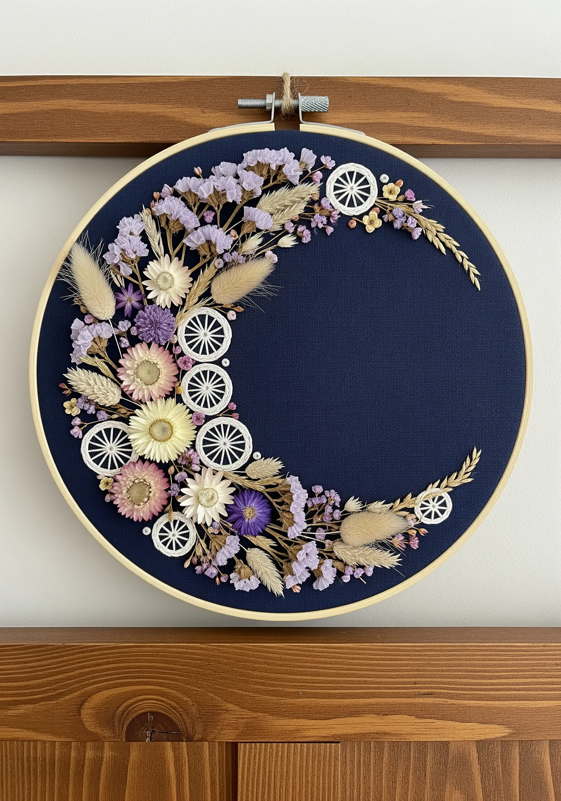 Crescent moon wreath combining real dried flowers and embroidered wheels on navy fabric