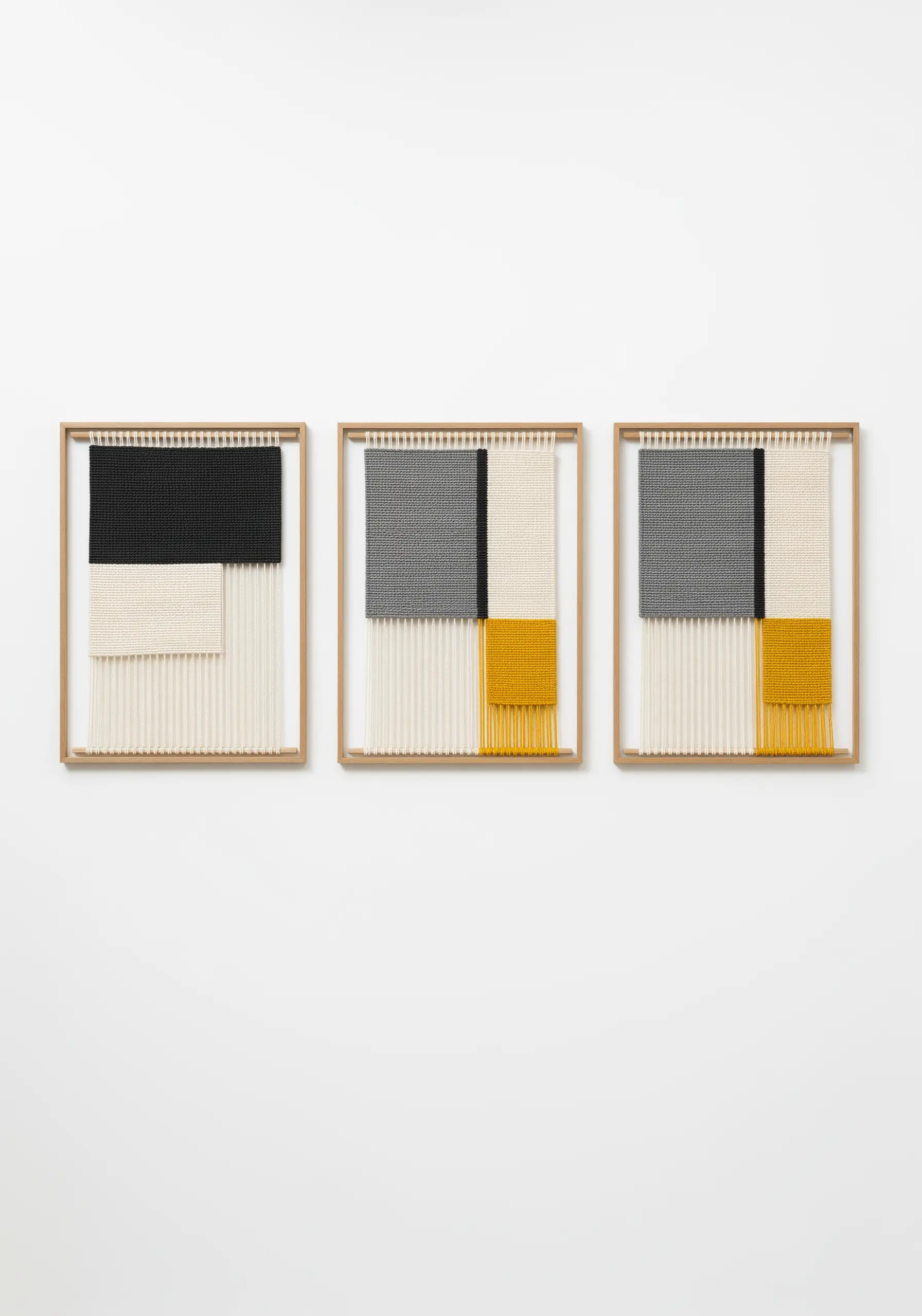 A triptych of three framed woven pieces with geometric blocks of black, grey, and yellow.