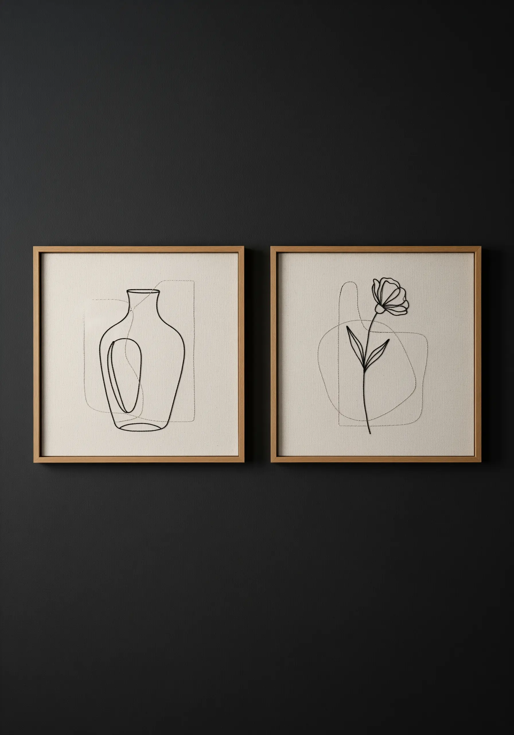 A pair of framed embroideries: a vase and a flower in black line art.