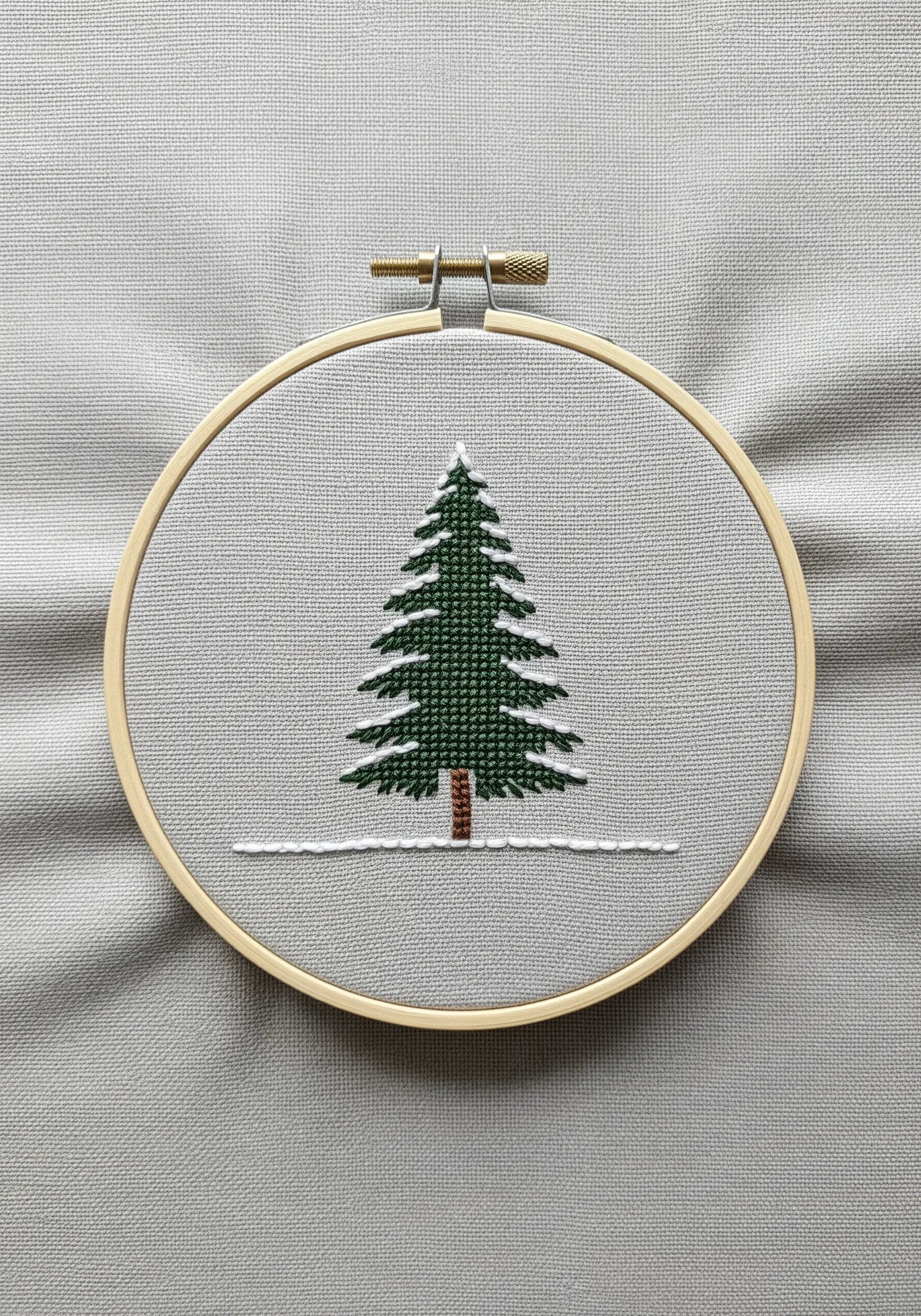 Graphic embroidered pine tree with snow on its branches using clean satin stitch.