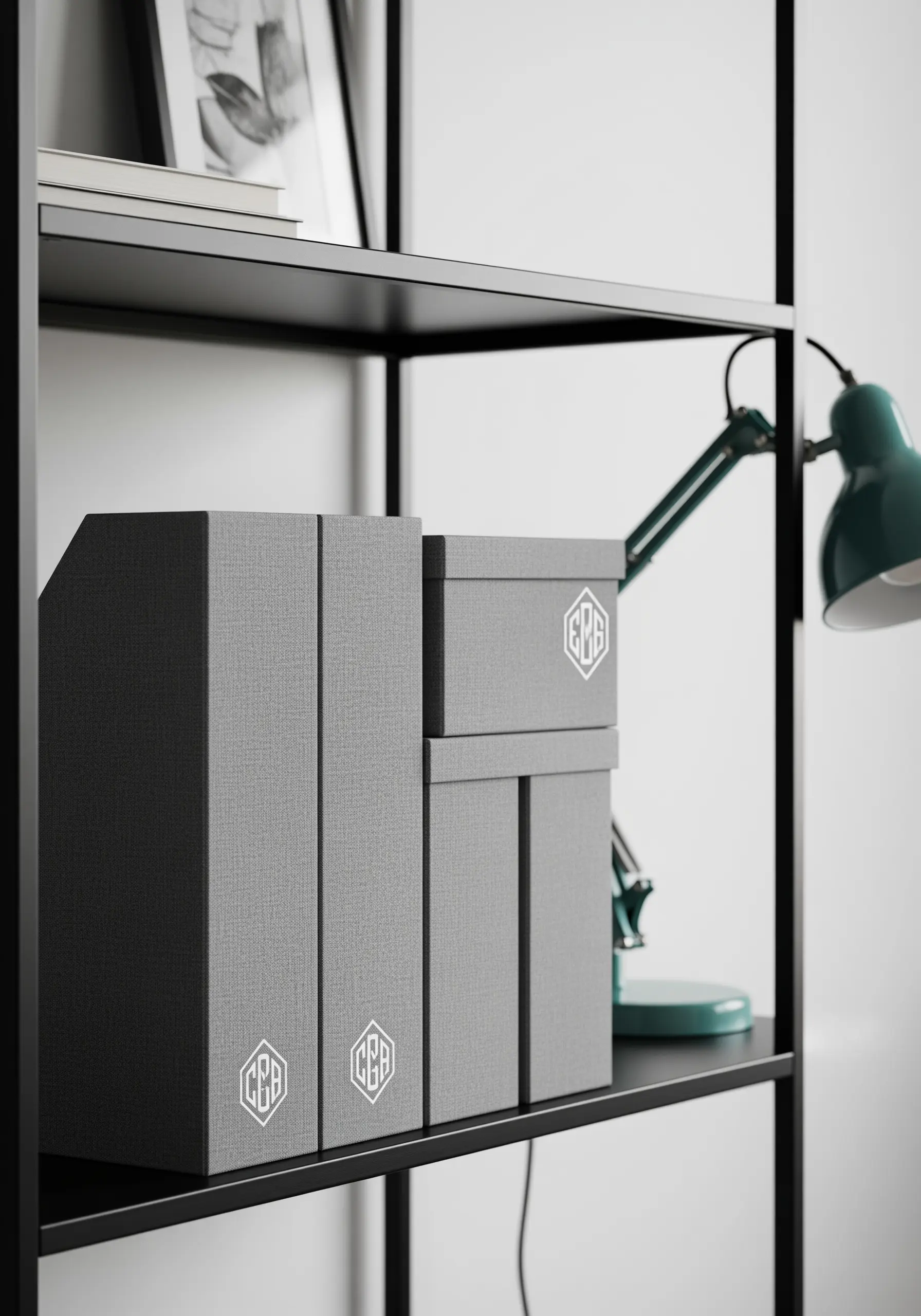 A white padded satin stitch monogram on gray fabric-covered office organizers.