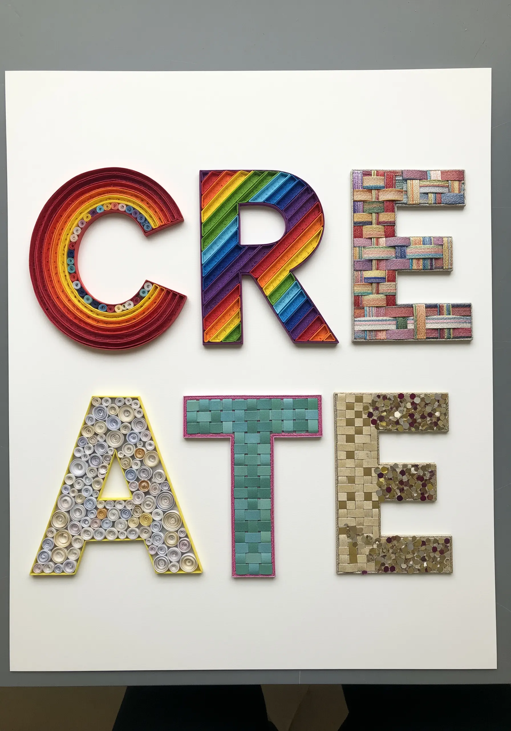 The word 'CREATE' with each letter made using a different paper craft technique.