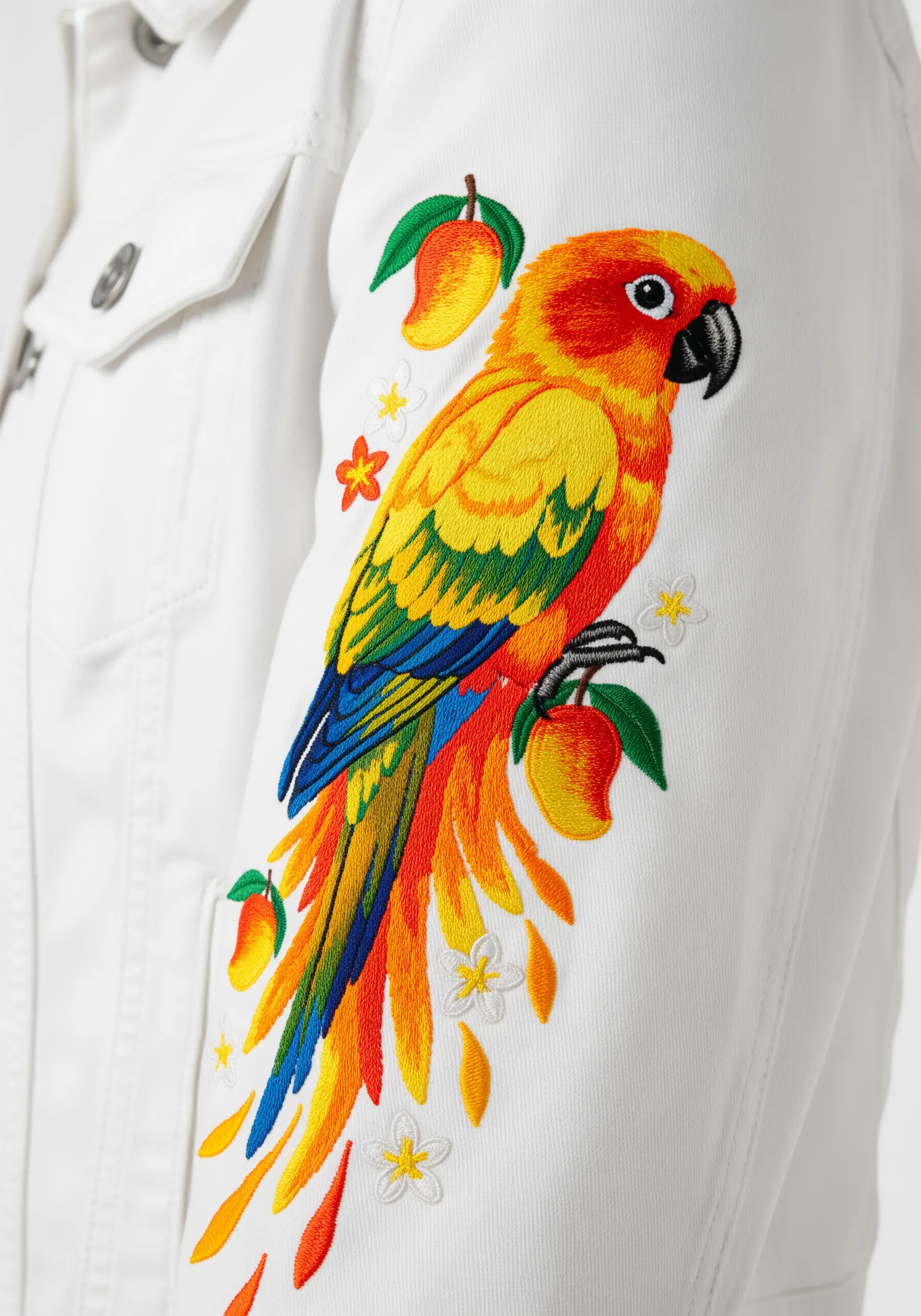 A vibrant Sun Conure parrot embroidered down the sleeve of a white denim jacket.