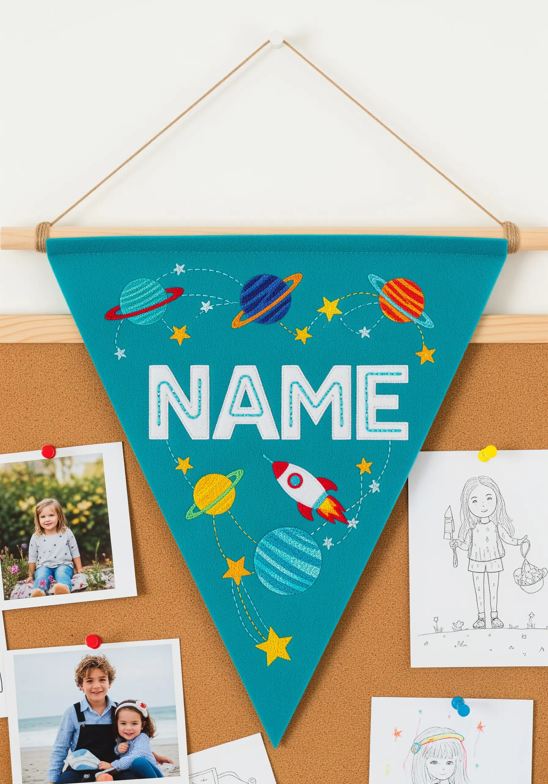 A personalized name pennant in teal felt with white appliqué letters and embroidered planets.