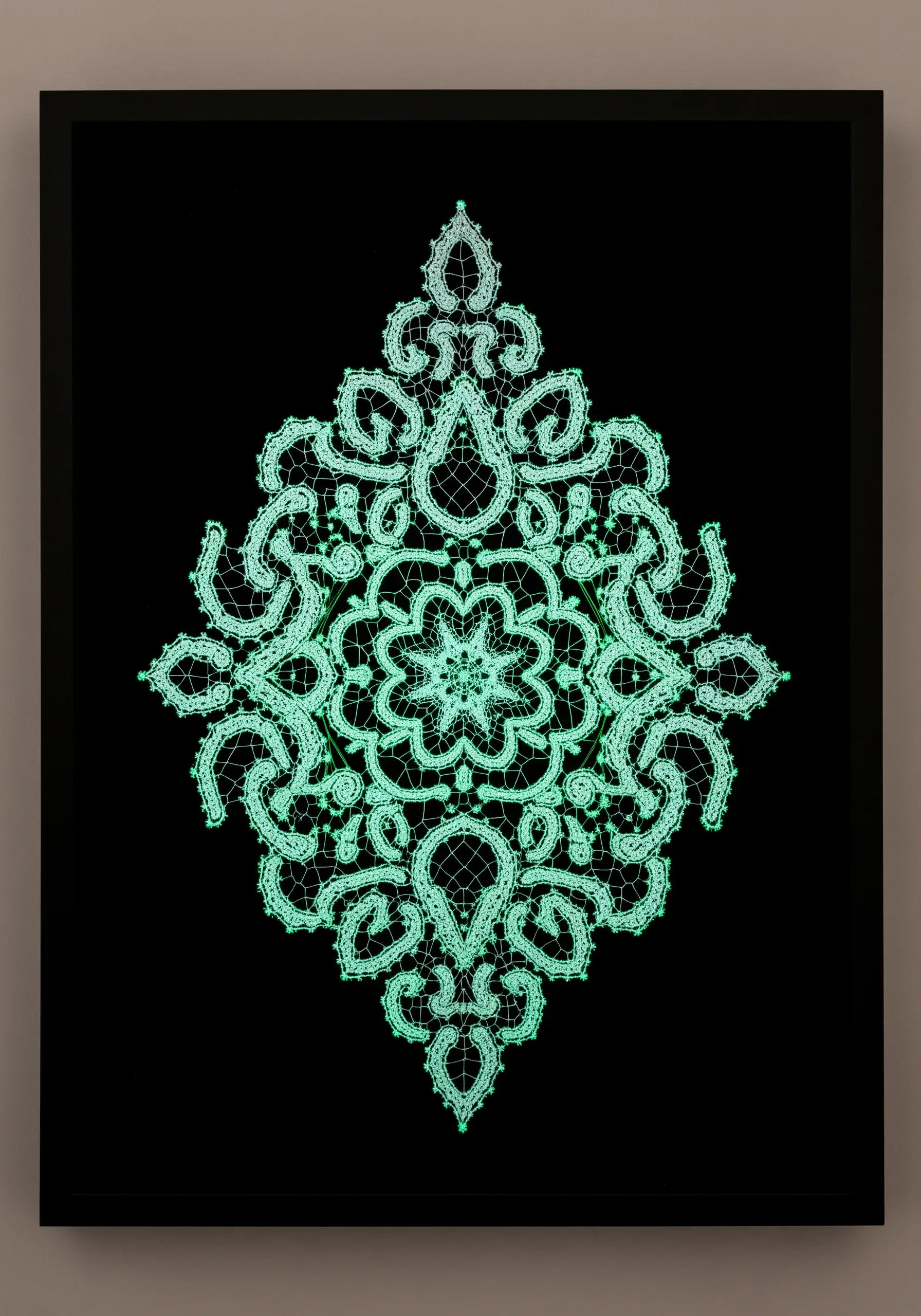 A traditional lace design, framed against black, glowing a vibrant green in the dark.
