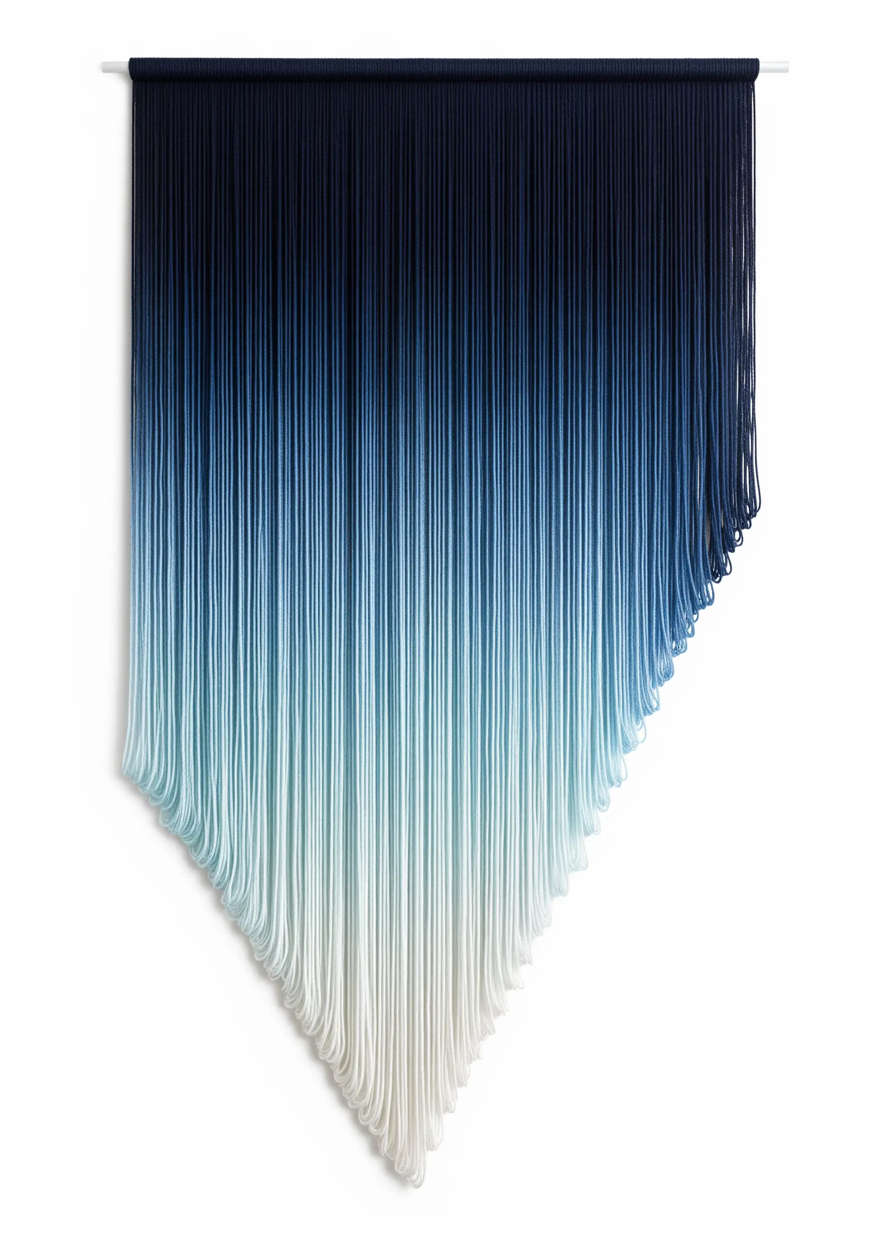 A minimalist yarn wall hanging with a dramatic blue-to-white ombre gradient cut in an asymmetrical shape.