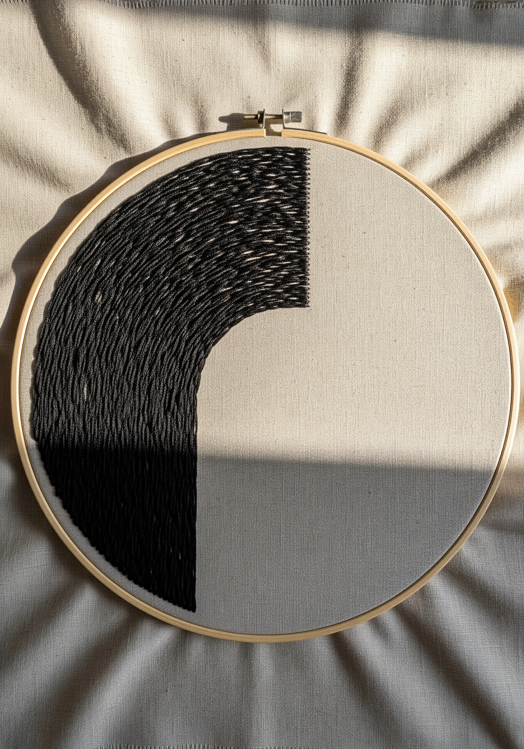Abstract black thread embroidery with dense, directional fill stitches in a half-circle shape.